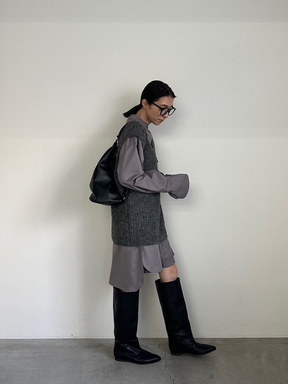 グレー系のシャツ/ブラウス、グレー系のベスト、ブラック系のブーツを着用したレディースの冬コーディネートの8枚目の写真