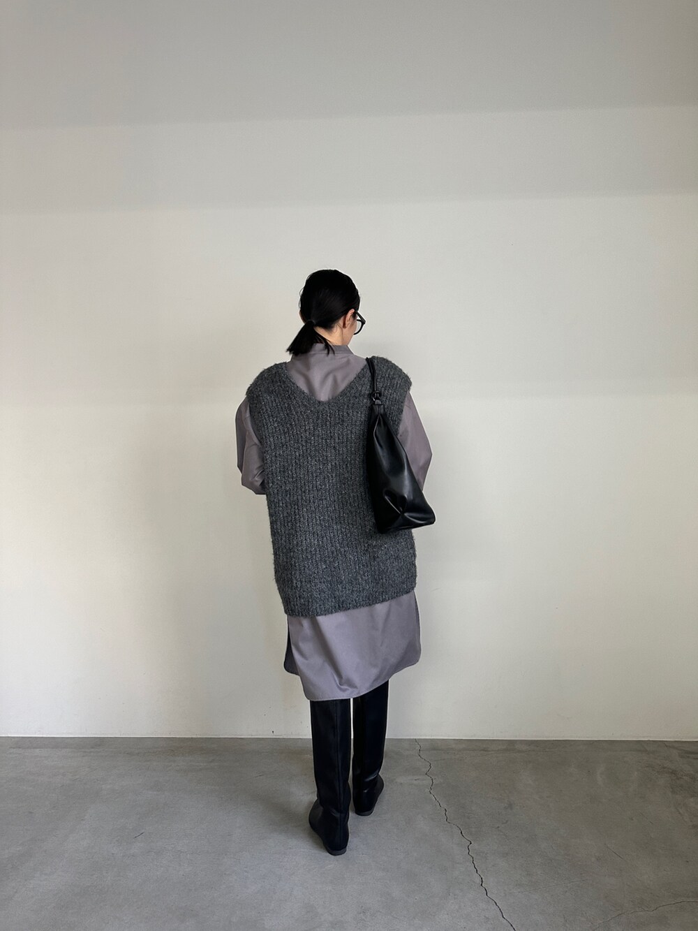 グレー系のシャツ/ブラウス、グレー系のベスト、ブラック系のブーツを着用したレディースの冬コーディネートの7枚目の写真