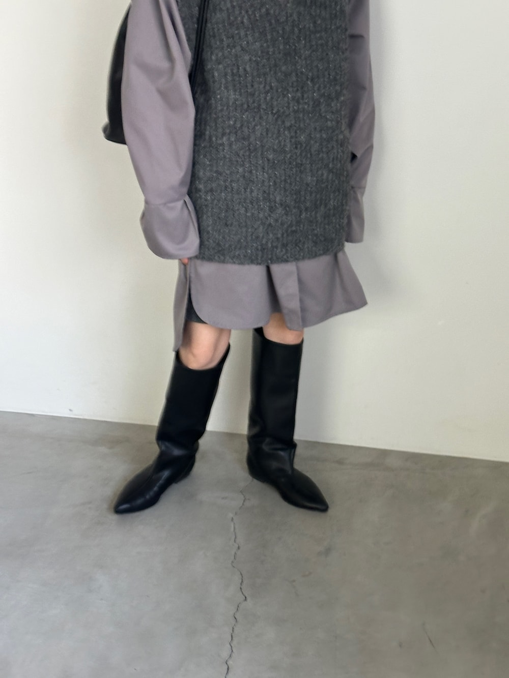 グレー系のシャツ/ブラウス、グレー系のベスト、ブラック系のブーツを着用したレディースの冬コーディネートの5枚目の写真