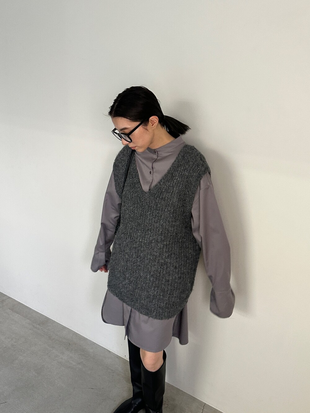 グレー系のシャツ/ブラウス、グレー系のベスト、ブラック系のブーツを着用したレディースの冬コーディネートの2枚目の写真