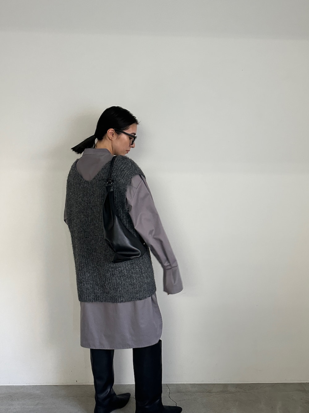 グレー系のシャツ/ブラウス、グレー系のベスト、ブラック系のブーツを着用したレディースの冬コーディネートの6枚目の写真