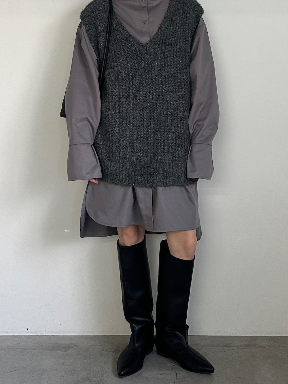 グレー系のシャツ/ブラウス、グレー系のベスト、ブラック系のブーツを着用したレディースの冬コーディネートの3枚目の写真