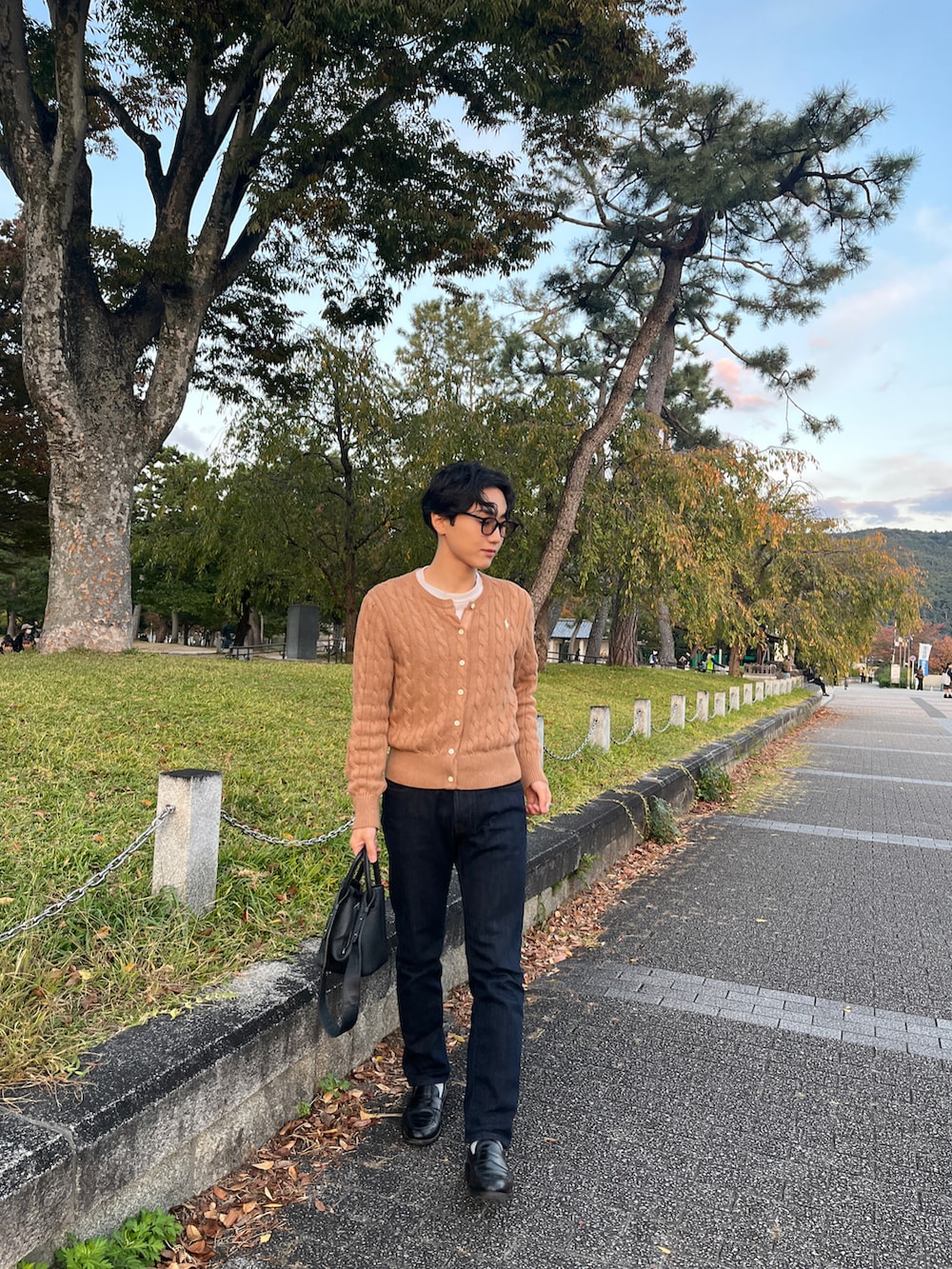 ブラウン系のカーディガン/ボレロ、ブルー系のデニムパンツ、ブラック系のローファーを着用したメンズの秋コーディネートの2枚目の写真