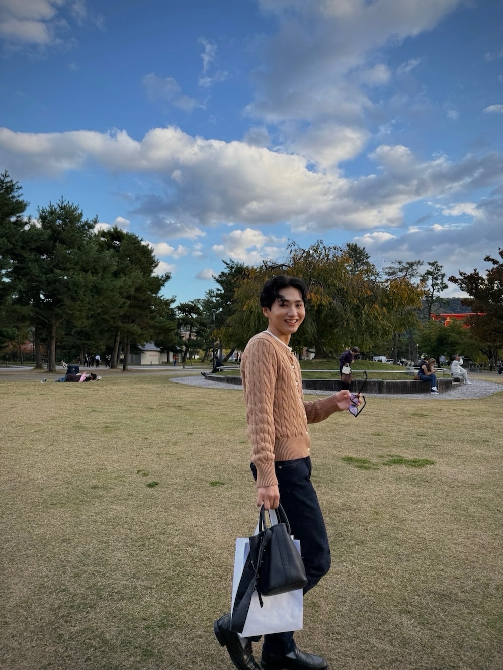 ブラウン系のカーディガン/ボレロ、ブルー系のデニムパンツ、ブラック系のローファーを着用したメンズの秋コーディネートの3枚目の写真