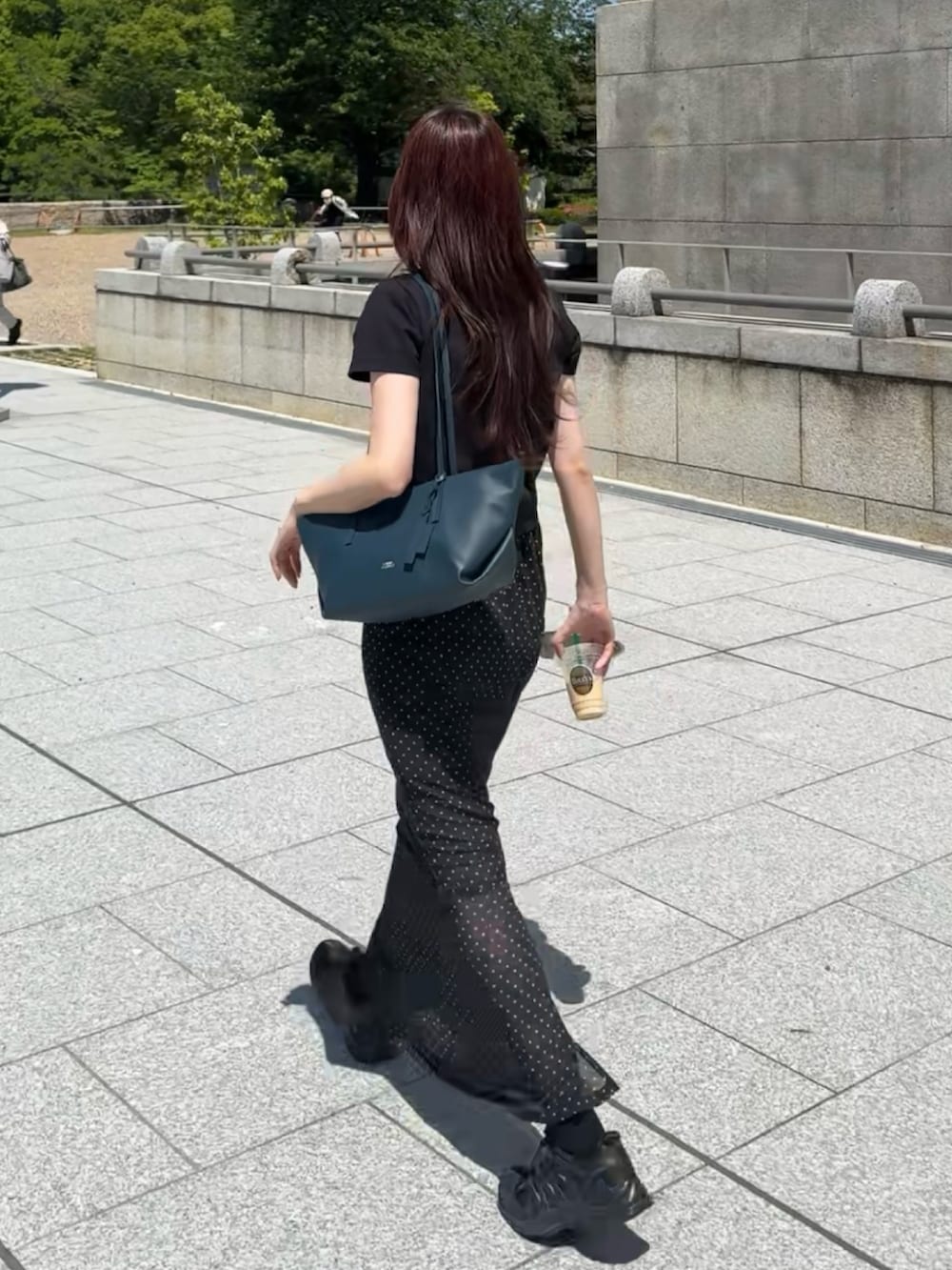 ブラック系のスカート、ブラック系のTシャツ/カットソー、ブラック系のスニーカーを着用したレディースの春コーディネートの2枚目の写真