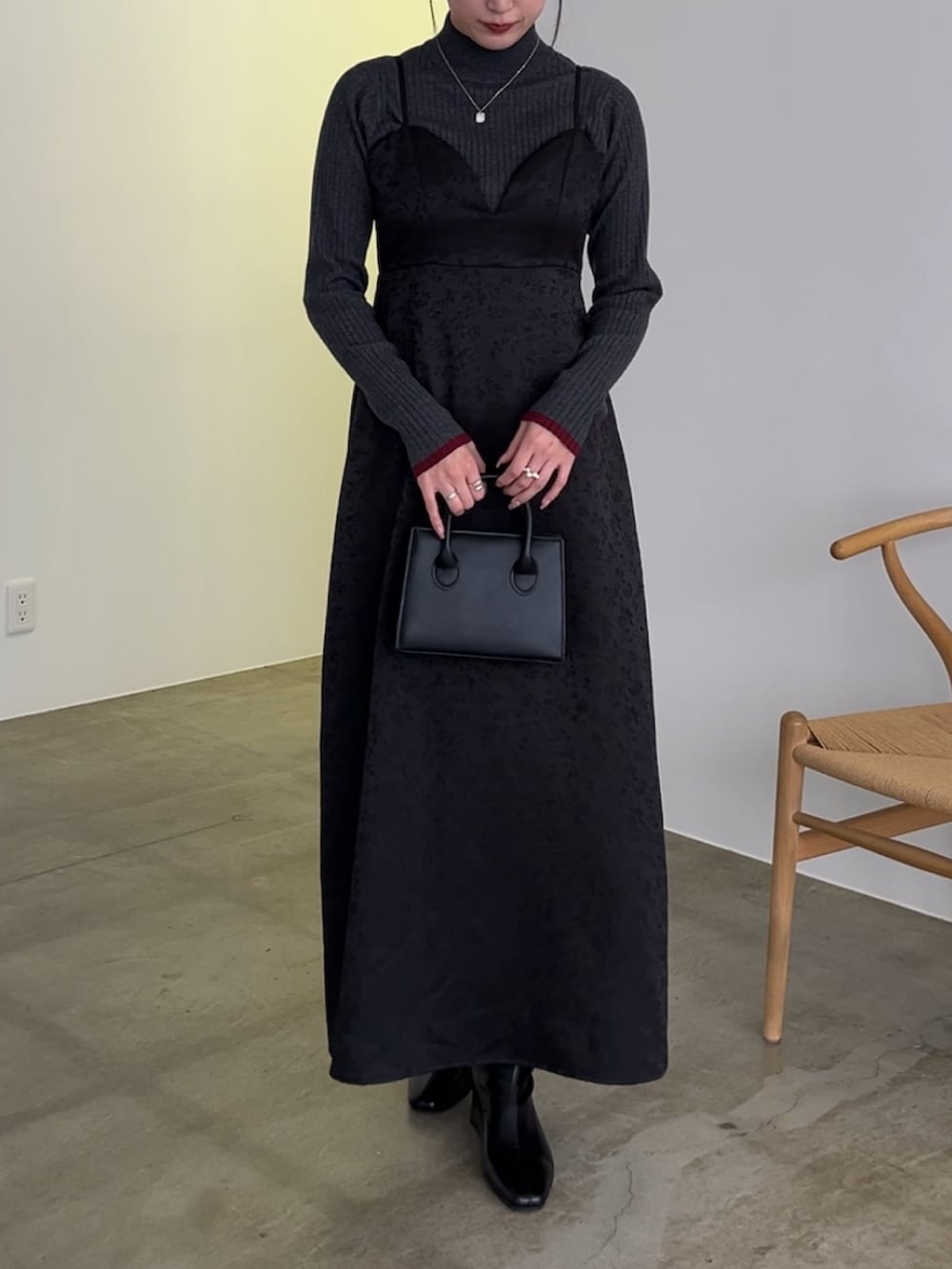 ブラック系のワンピース、グレー系のニット/セーターを着用したレディースの冬コーディネートの2枚目の写真