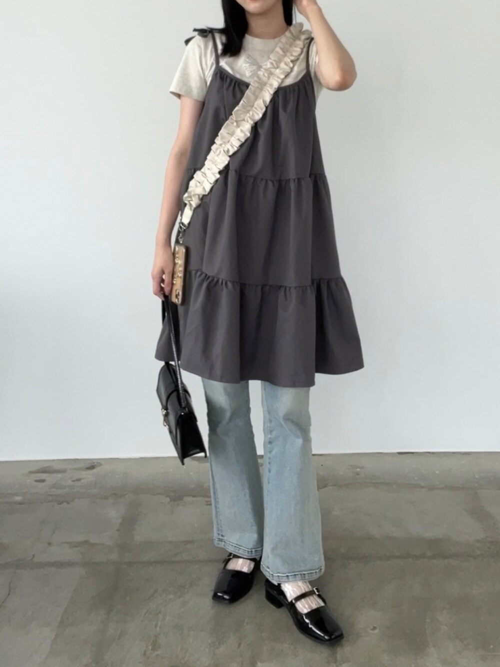 ブルー系のデニムパンツ、グレー系のワンピースを着用したレディースの夏コーディネートの2枚目の写真