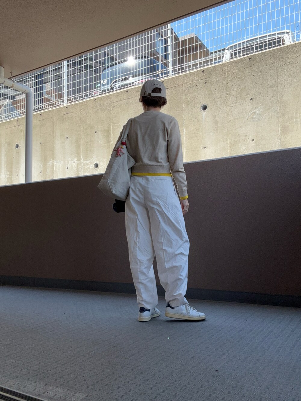 ホワイト系のパンツ、ホワイト系のスニーカー、ベージュ系のカーディガン/ボレロを着用したレディースの春コーディネートの2枚目の写真