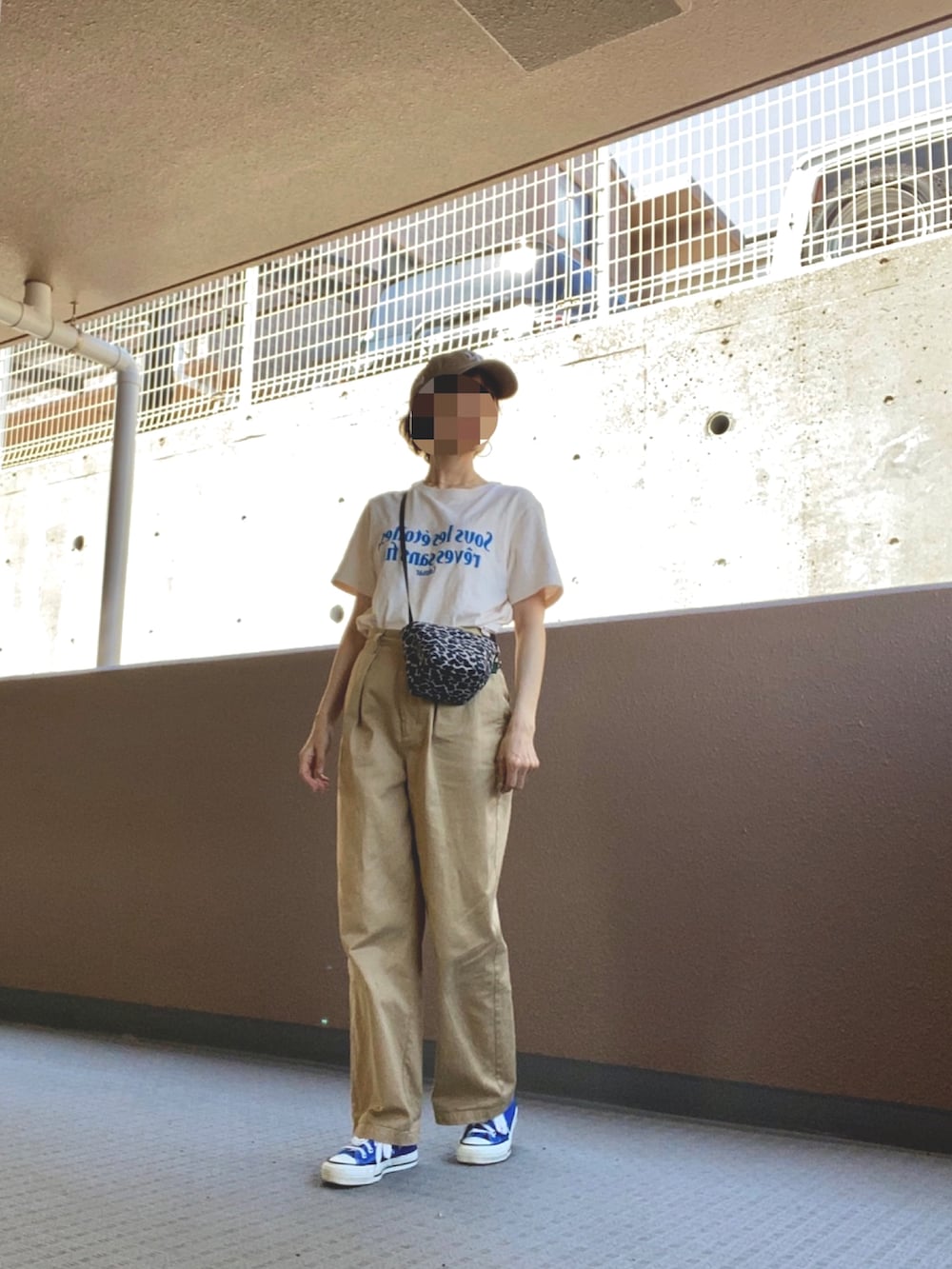 ベージュ系のチノパンツ、ホワイト系のシャツ/ブラウス、ブラック系のトートバッグを着用したレディースの夏コーディネートの2枚目の写真