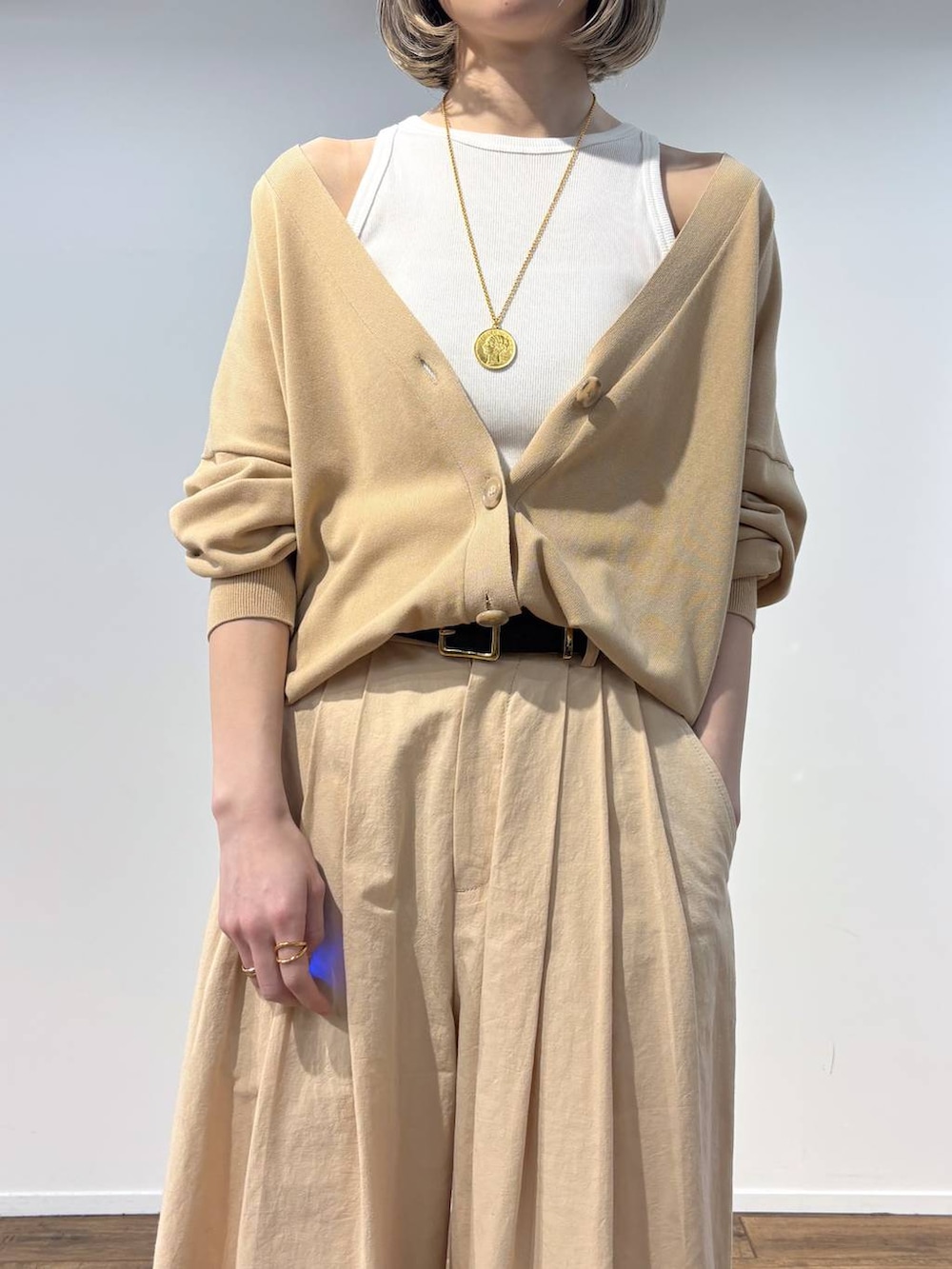 ホワイト系のアンサンブル、ベージュ系のカーディガン/ボレロ、ベージュ系のその他パンツを着用したレディースの春コーディネートの4枚目の写真