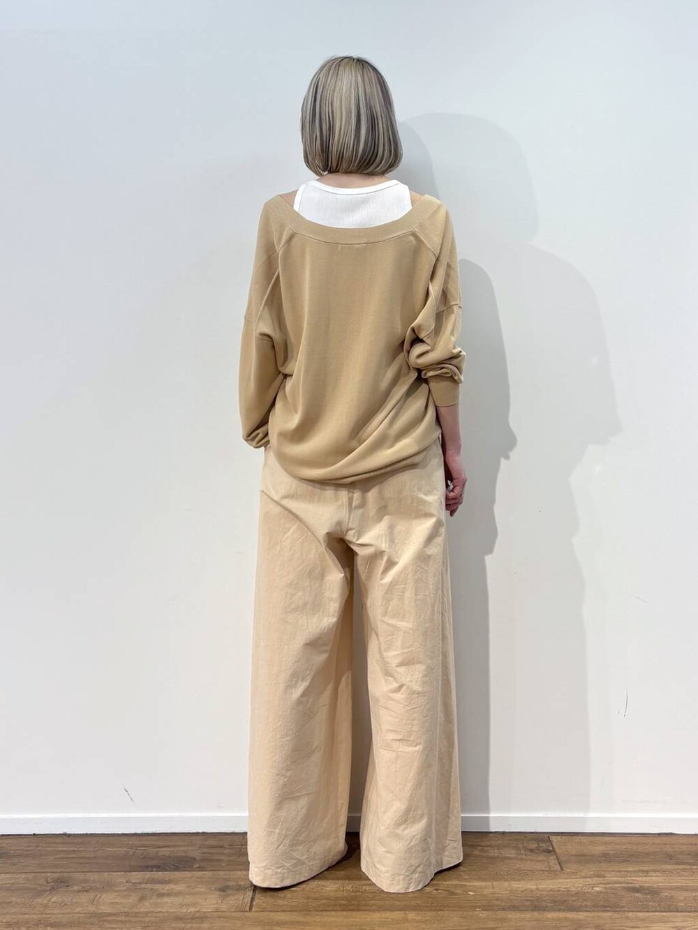 ホワイト系のアンサンブル、ベージュ系のカーディガン/ボレロ、ベージュ系のその他パンツを着用したレディースの春コーディネートの3枚目の写真