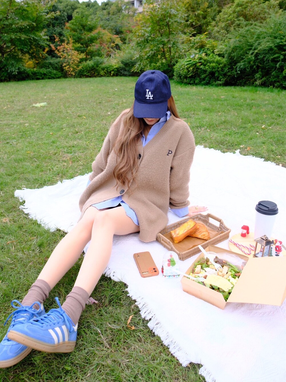 ブルー系のスニーカーを着用したレディースの秋コーディネートの2枚目の写真