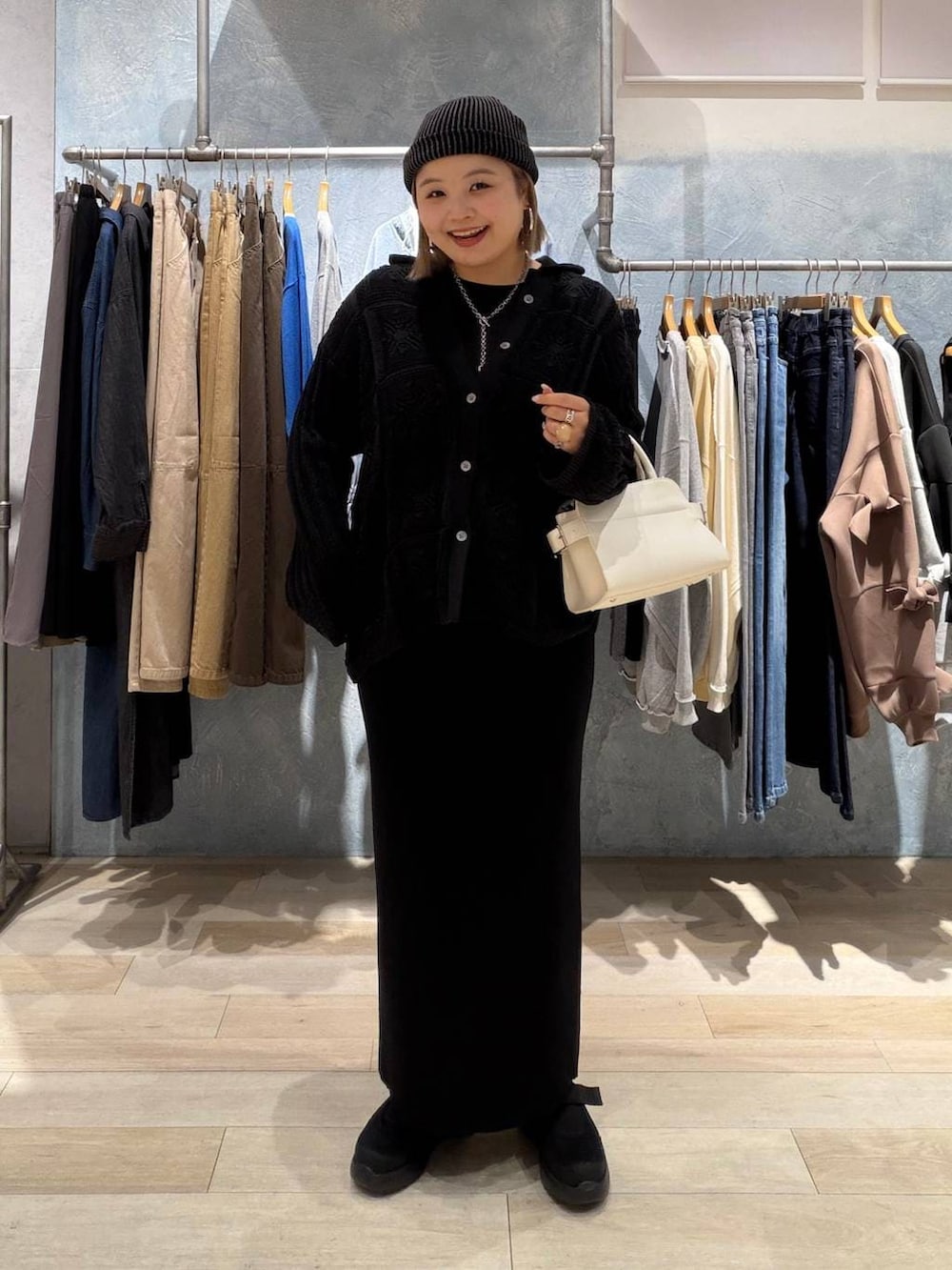 ブラック系のTシャツ/カットソー、ブラック系のスカート、ホワイト系のショルダーバッグを着用したレディースの春コーディネートの5枚目の写真