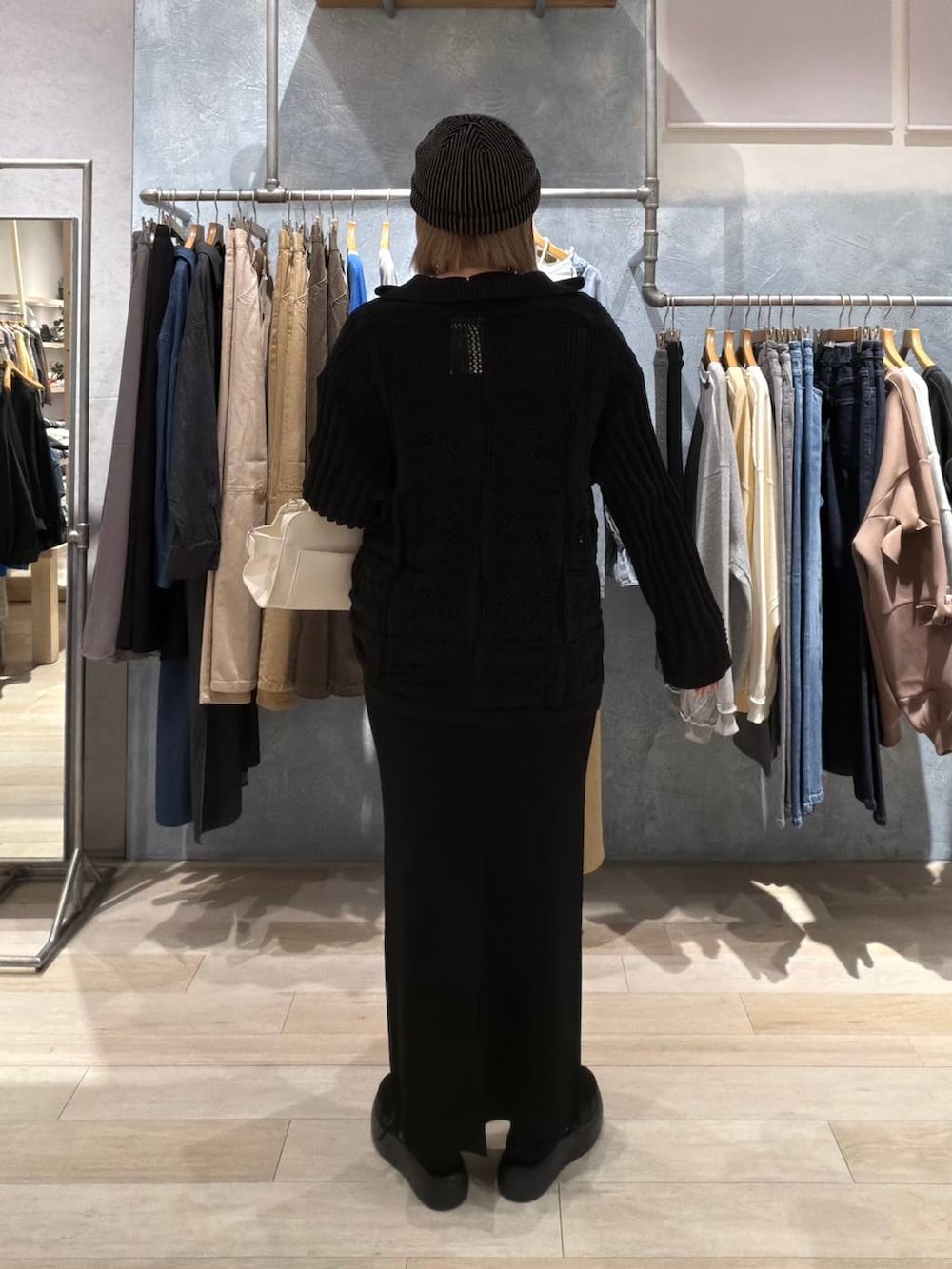 ブラック系のTシャツ/カットソー、ブラック系のスカート、ホワイト系のショルダーバッグを着用したレディースの春コーディネートの4枚目の写真