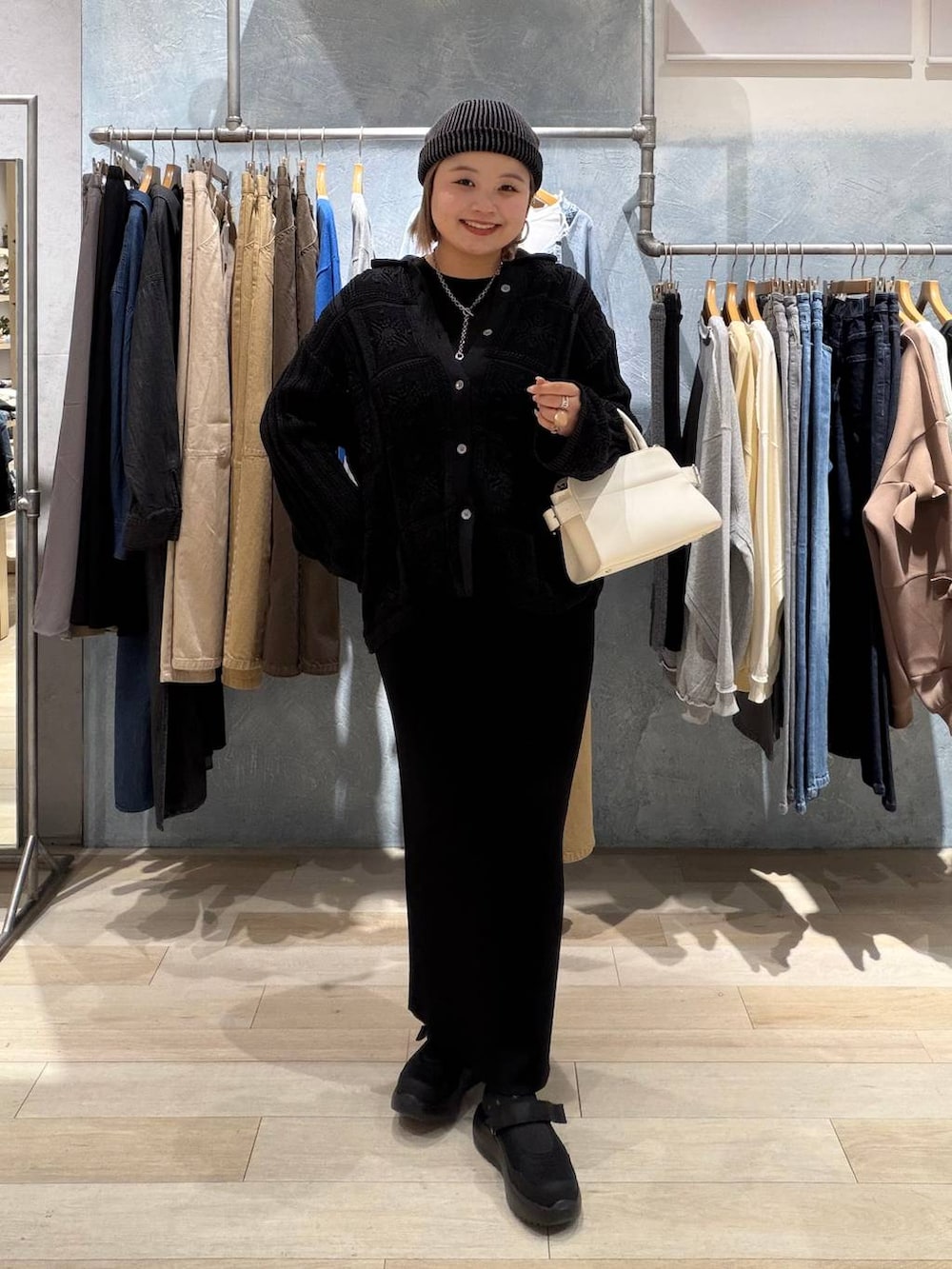 ブラック系のTシャツ/カットソー、ブラック系のスカート、ホワイト系のショルダーバッグを着用したレディースの春コーディネートの6枚目の写真