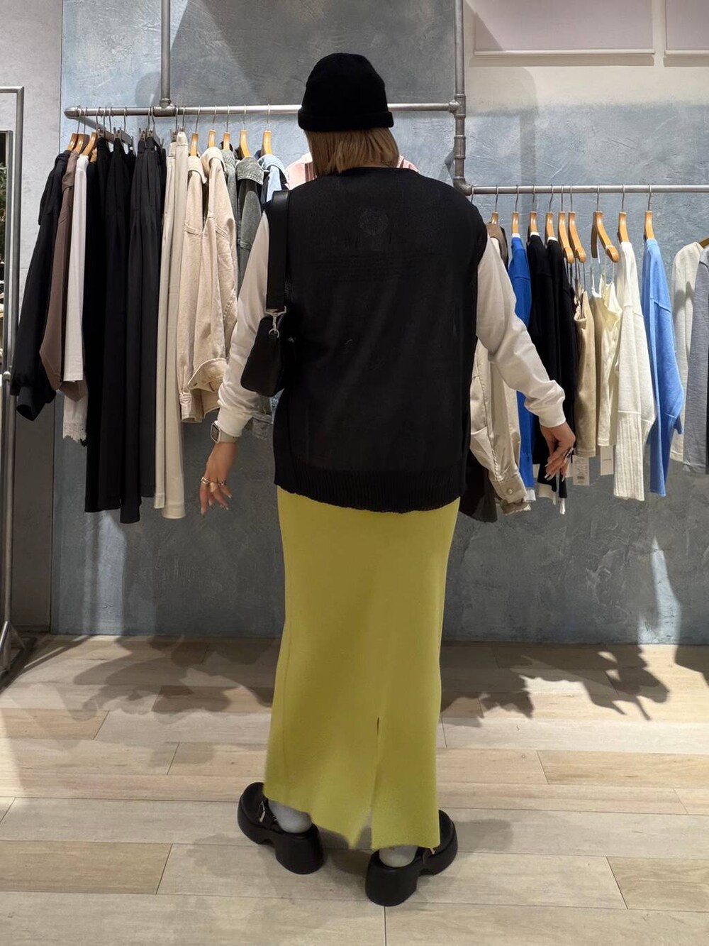 グリーン系のスカート、ブラック系のサンダル、ブラック系のショルダーバッグを着用したレディースの春コーディネートの4枚目の写真