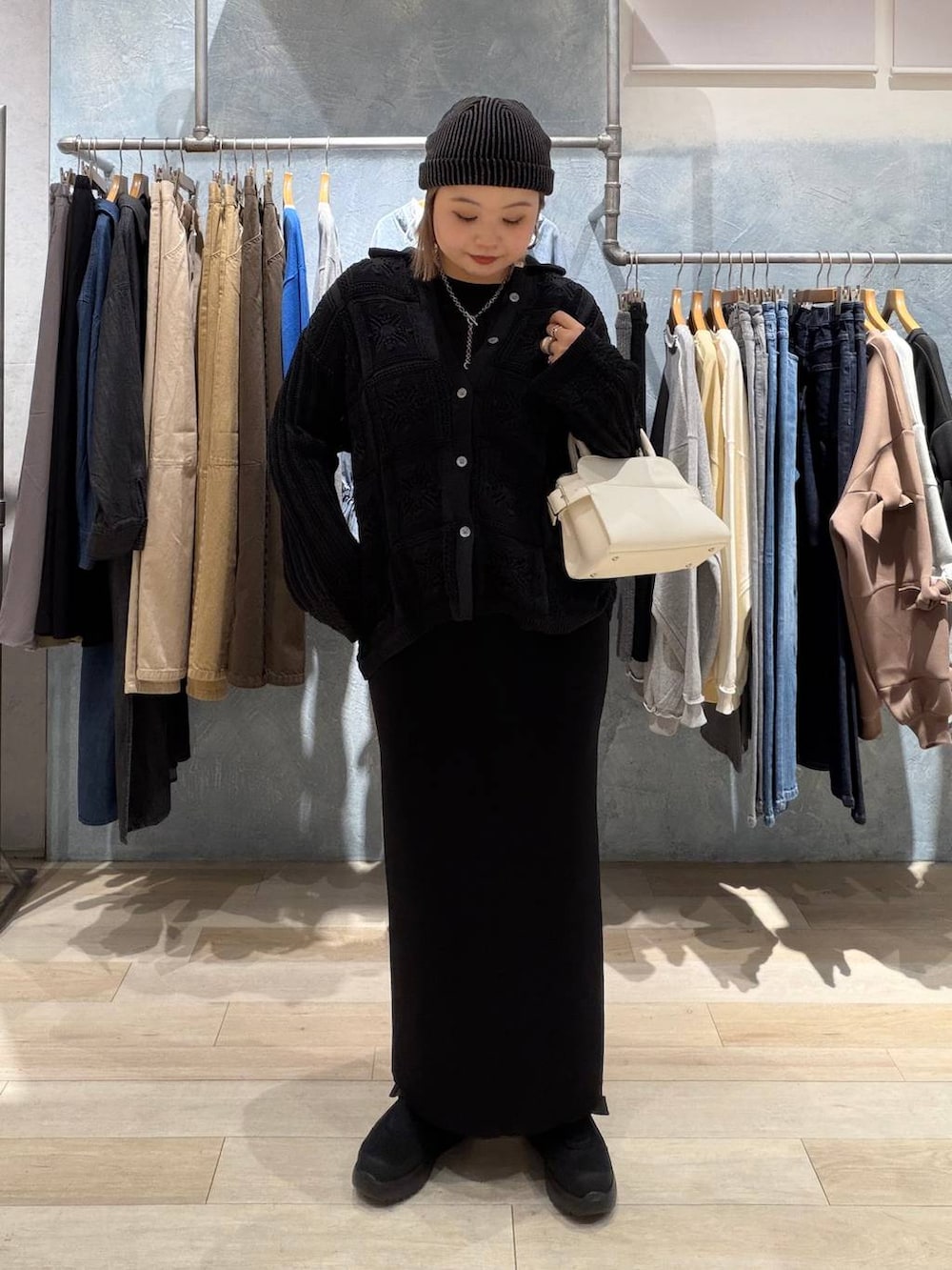 ブラック系のTシャツ/カットソー、ブラック系のスカート、ホワイト系のショルダーバッグを着用したレディースの春コーディネートの2枚目の写真