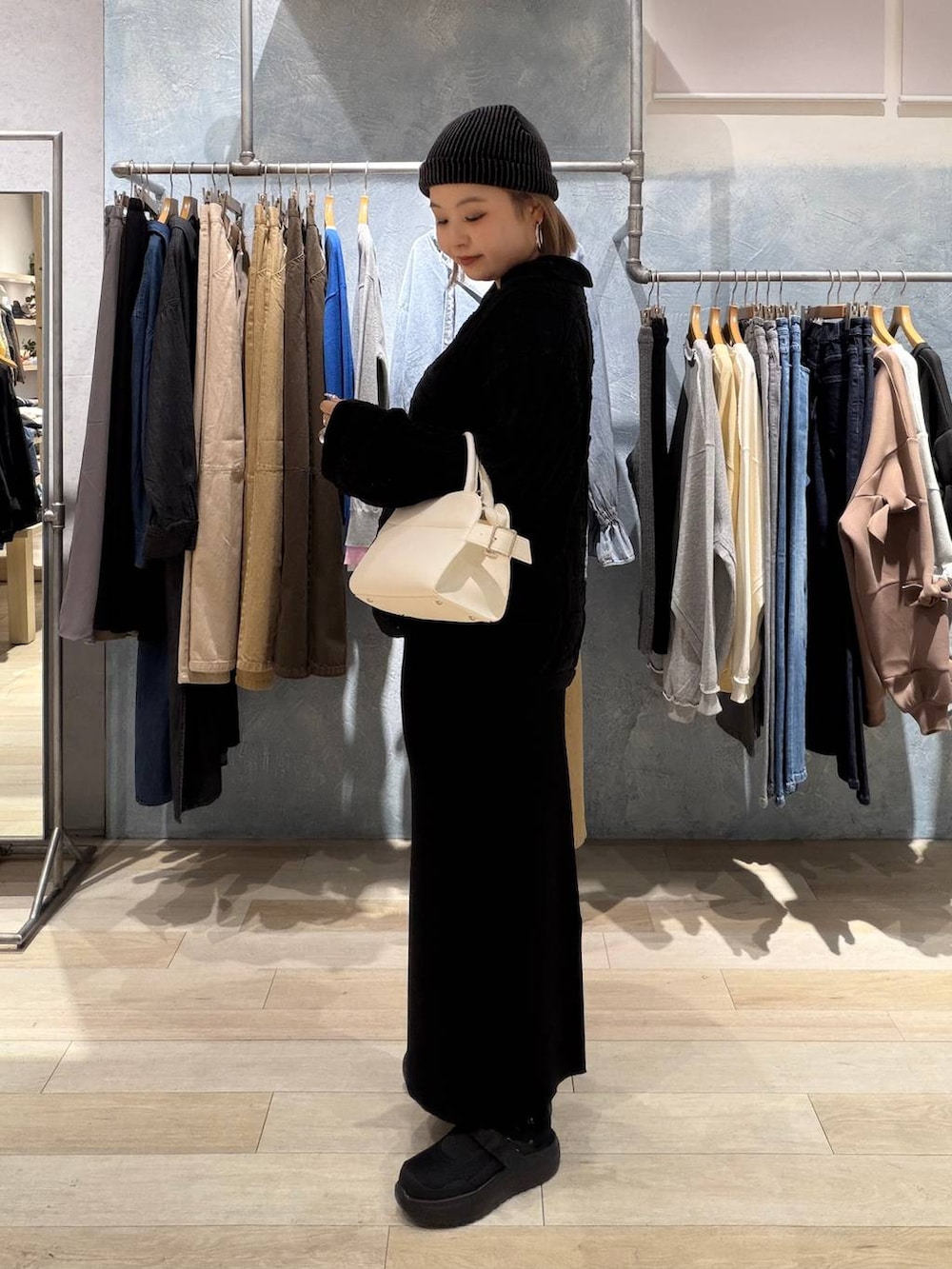 ブラック系のTシャツ/カットソー、ブラック系のスカート、ホワイト系のショルダーバッグを着用したレディースの春コーディネートの3枚目の写真