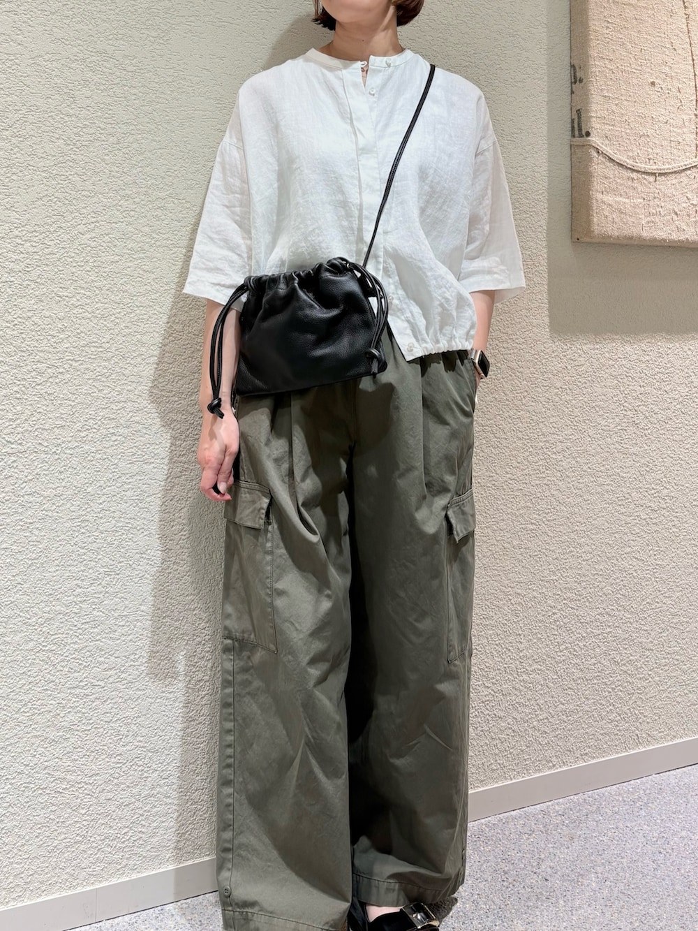 ホワイト系のシャツ/ブラウス、グリーン系のその他パンツ、ブラック系のショルダーバッグを着用したレディースの夏コーディネートの5枚目の写真
