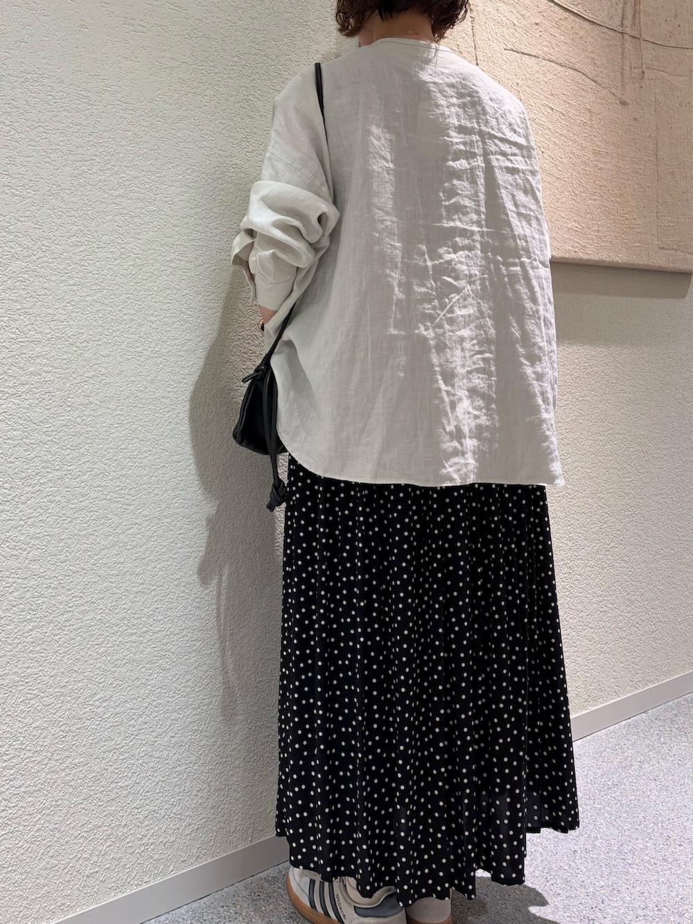 グレー系のシャツ/ブラウス、ブラック系のスカート、ブラック系のショルダーバッグを着用したレディースの春コーディネートの5枚目の写真