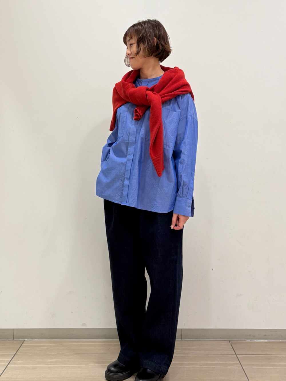 レッド系のニット/セーター、ブルー系のシャツ/ブラウス、ブルー系のその他パンツを着用したレディースの冬コーディネートの3枚目の写真
