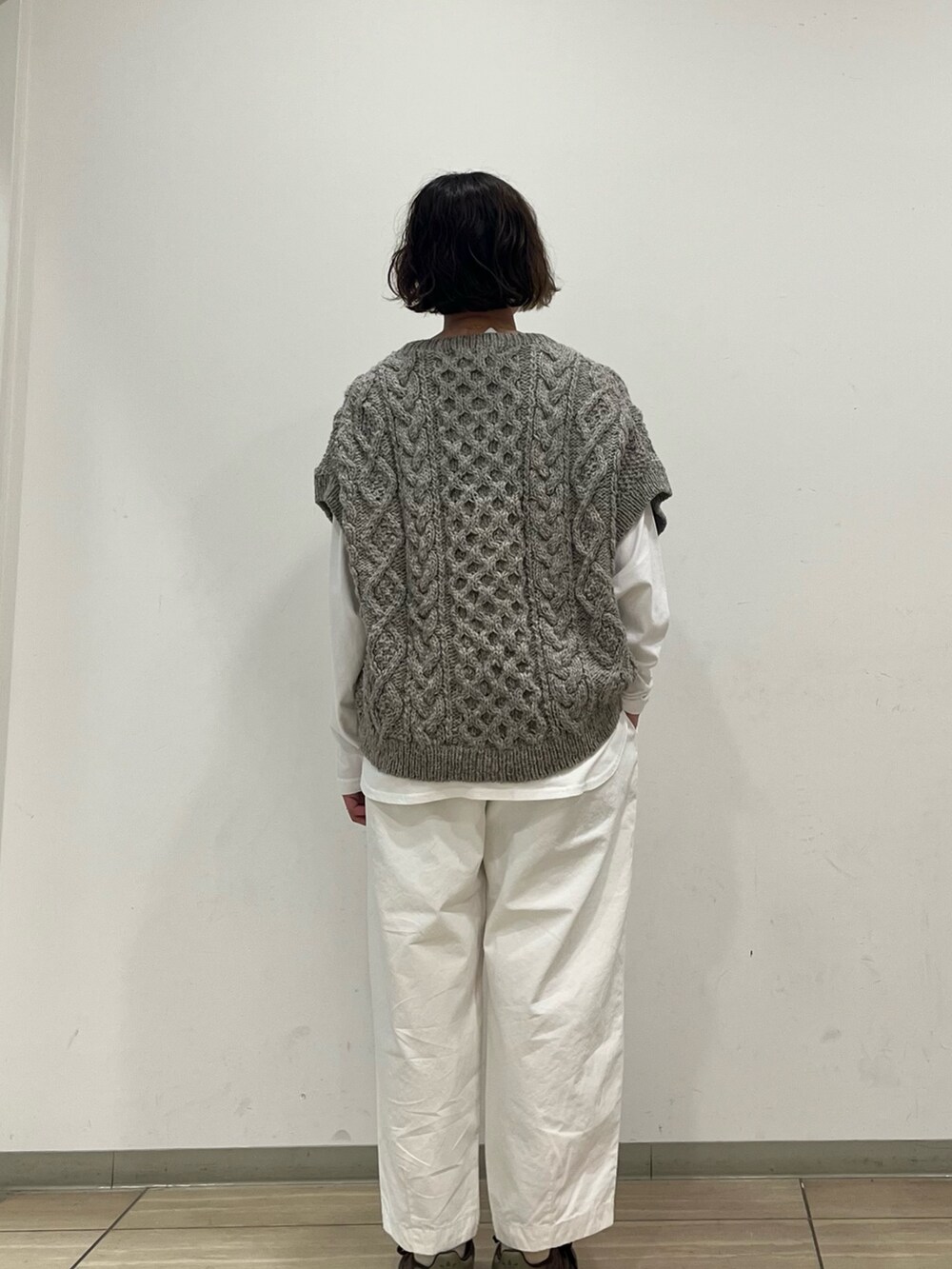 グリーン系のニット/セーター、ホワイト系のTシャツ/カットソー、ホワイト系のその他パンツを着用したレディースの秋コーディネートの4枚目の写真