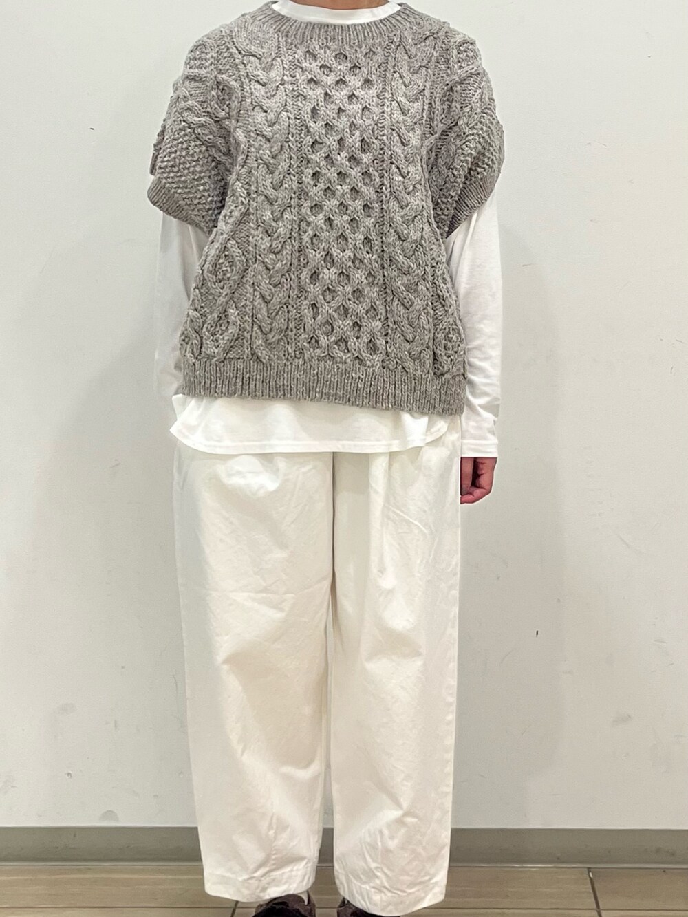 グリーン系のニット/セーター、ホワイト系のTシャツ/カットソー、ホワイト系のその他パンツを着用したレディースの秋コーディネートの5枚目の写真