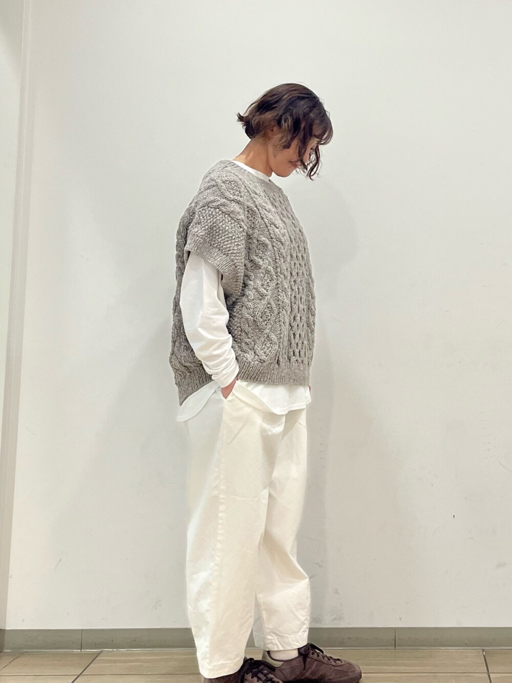 グリーン系のニット/セーター、ホワイト系のTシャツ/カットソー、ホワイト系のその他パンツを着用したレディースの秋コーディネートの3枚目の写真