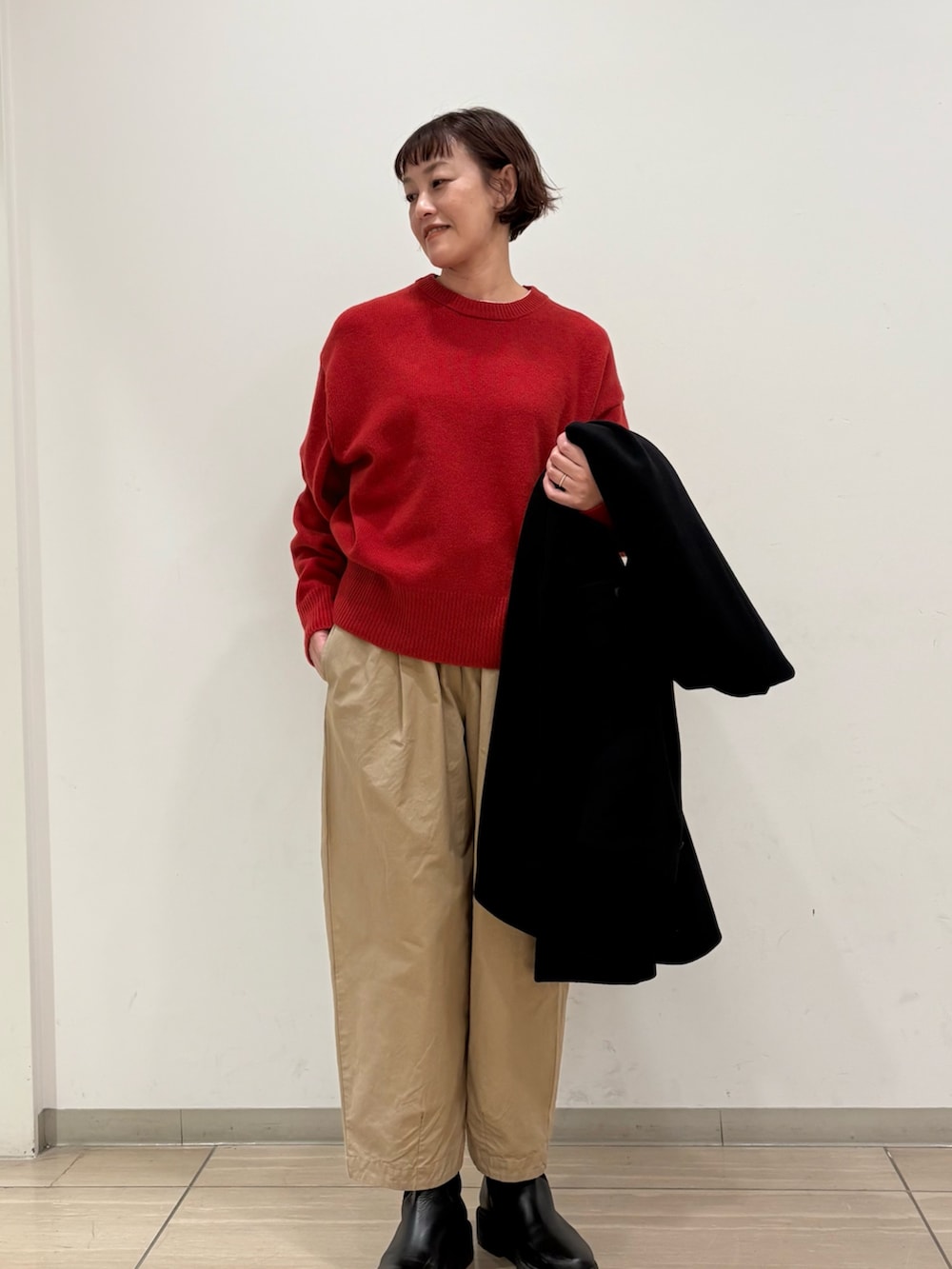 ブラック系のステンカラーコート、パープル系のその他パンツ、レッド系のニット/セーターを着用したレディースの冬コーディネートの4枚目の写真