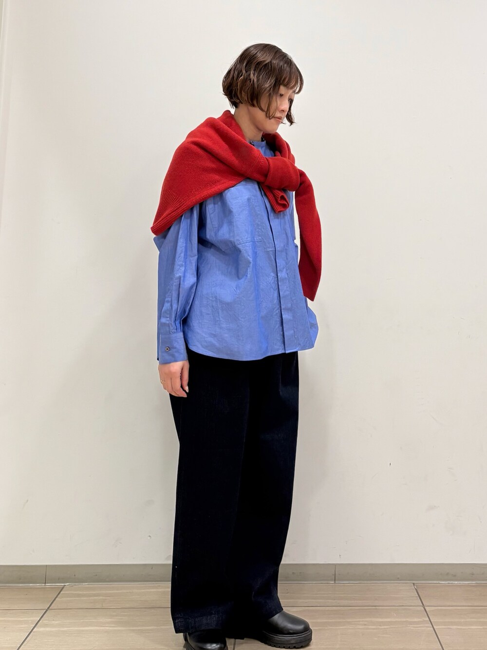 レッド系のニット/セーター、ブルー系のシャツ/ブラウス、ブルー系のその他パンツを着用したレディースの冬コーディネートの4枚目の写真