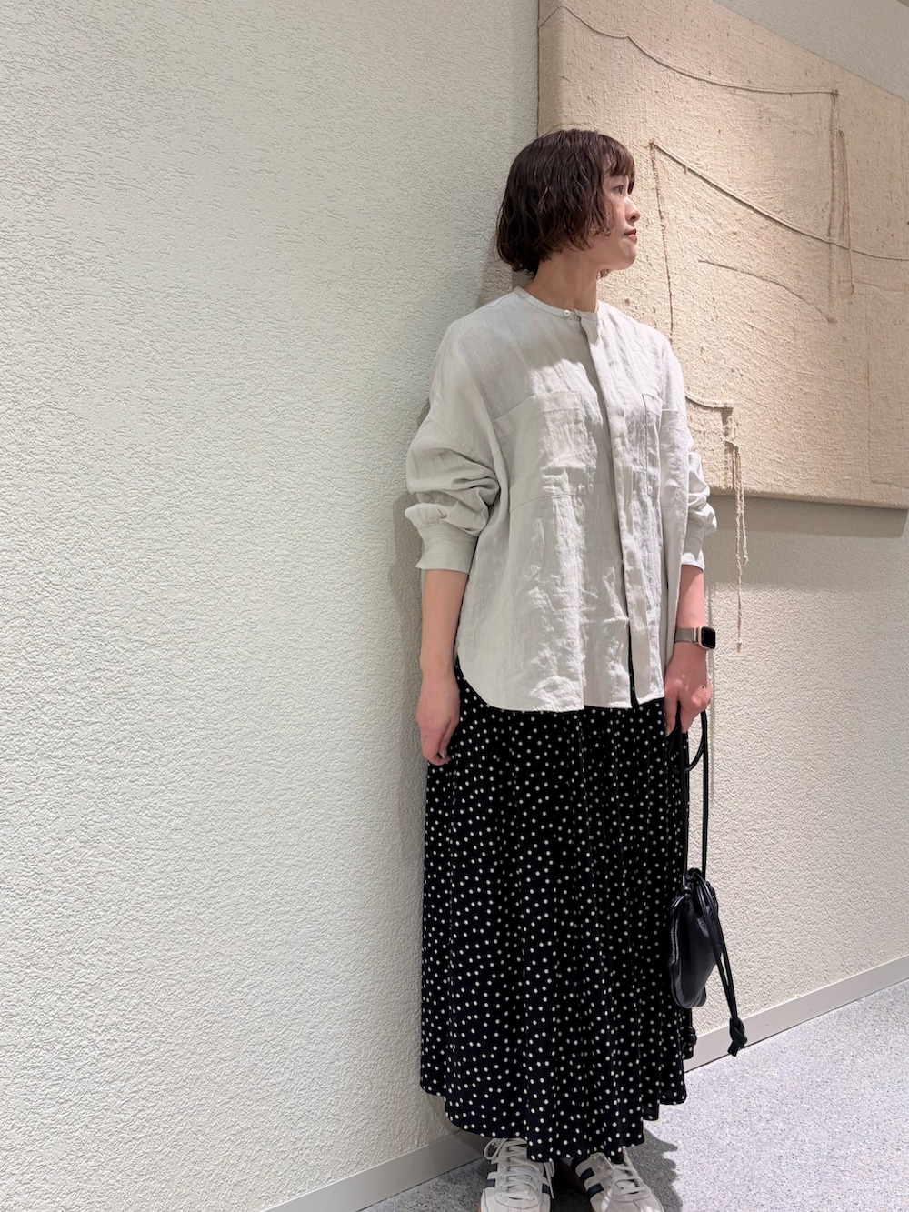 グレー系のシャツ/ブラウス、ブラック系のスカート、ブラック系のショルダーバッグを着用したレディースの春コーディネートの4枚目の写真