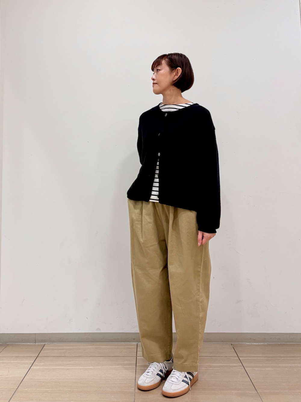 ブラック系のカーディガン/ボレロ、ブラック系のTシャツ/カットソー、ベージュ系のその他パンツを着用したレディースの冬コーディネートの3枚目の写真