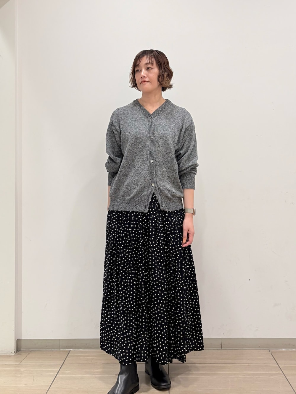 グレー系のニット/セーター、ブラック系のスカートを着用したレディースの冬コーディネートの2枚目の写真