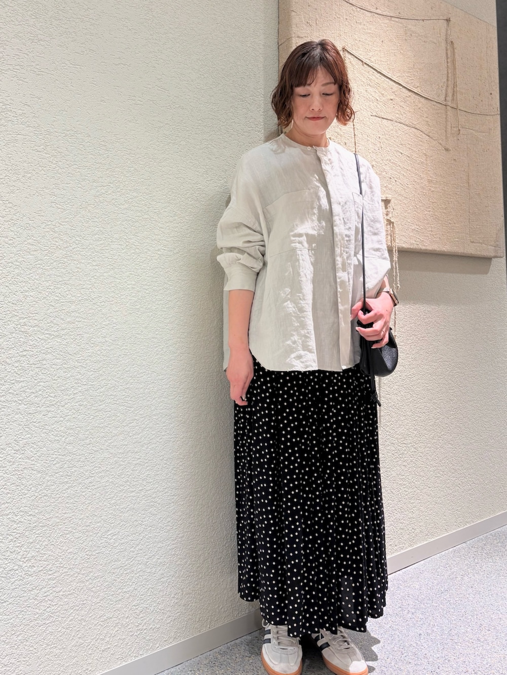 グレー系のシャツ/ブラウス、ブラック系のスカート、ブラック系のショルダーバッグを着用したレディースの春コーディネートの3枚目の写真