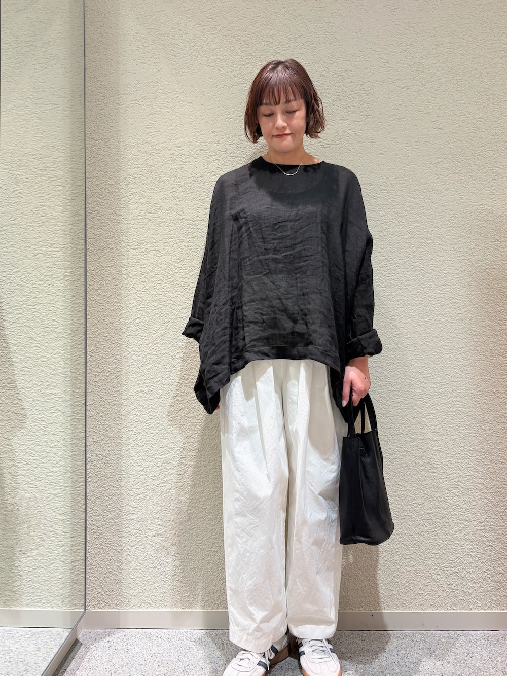 ブラック系のシャツ/ブラウス、ホワイト系のその他パンツ、ブラック系のトートバッグを着用したレディースの春コーディネートの2枚目の写真