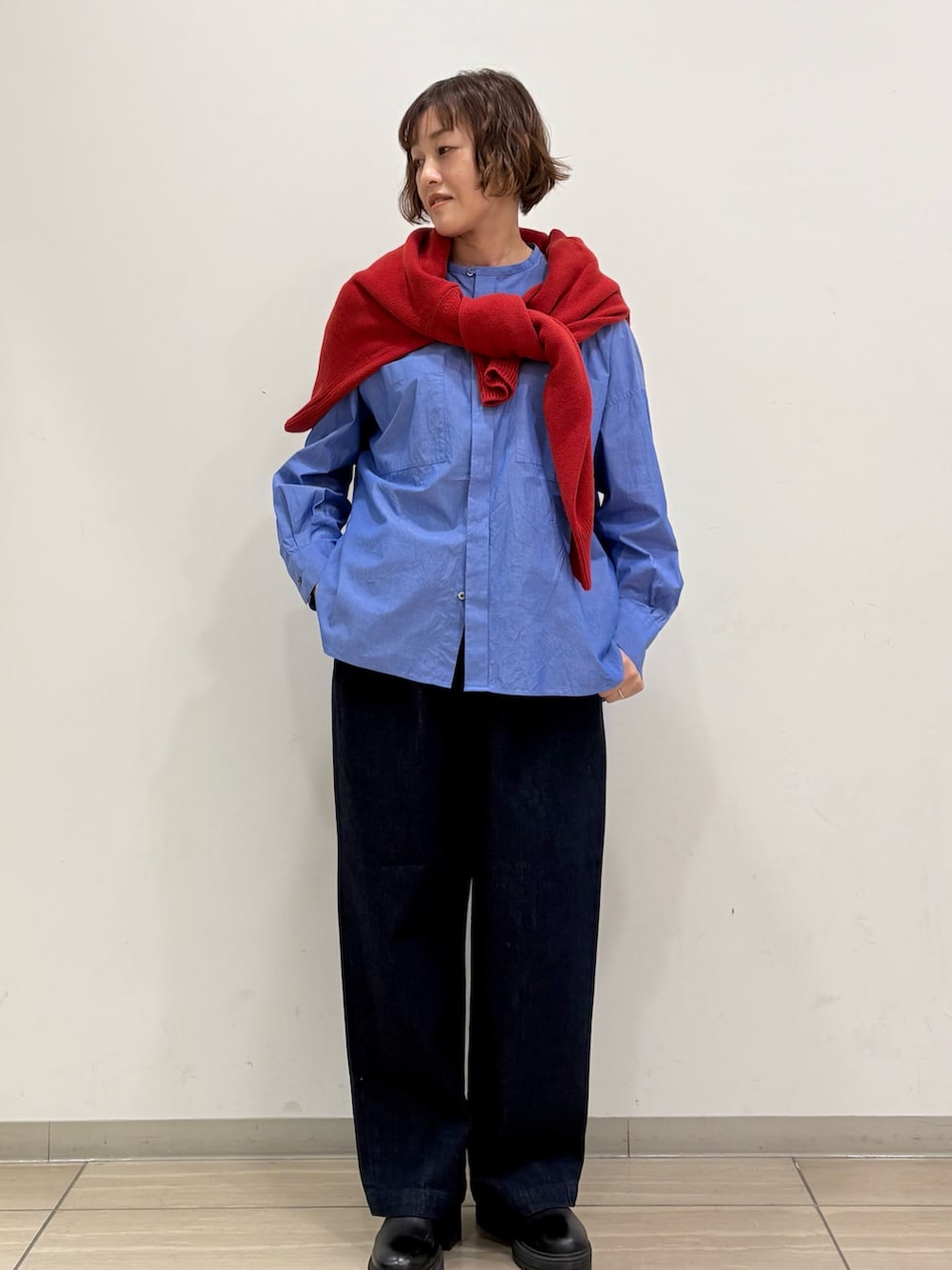レッド系のニット/セーター、ブルー系のシャツ/ブラウス、ブルー系のその他パンツを着用したレディースの冬コーディネートの2枚目の写真