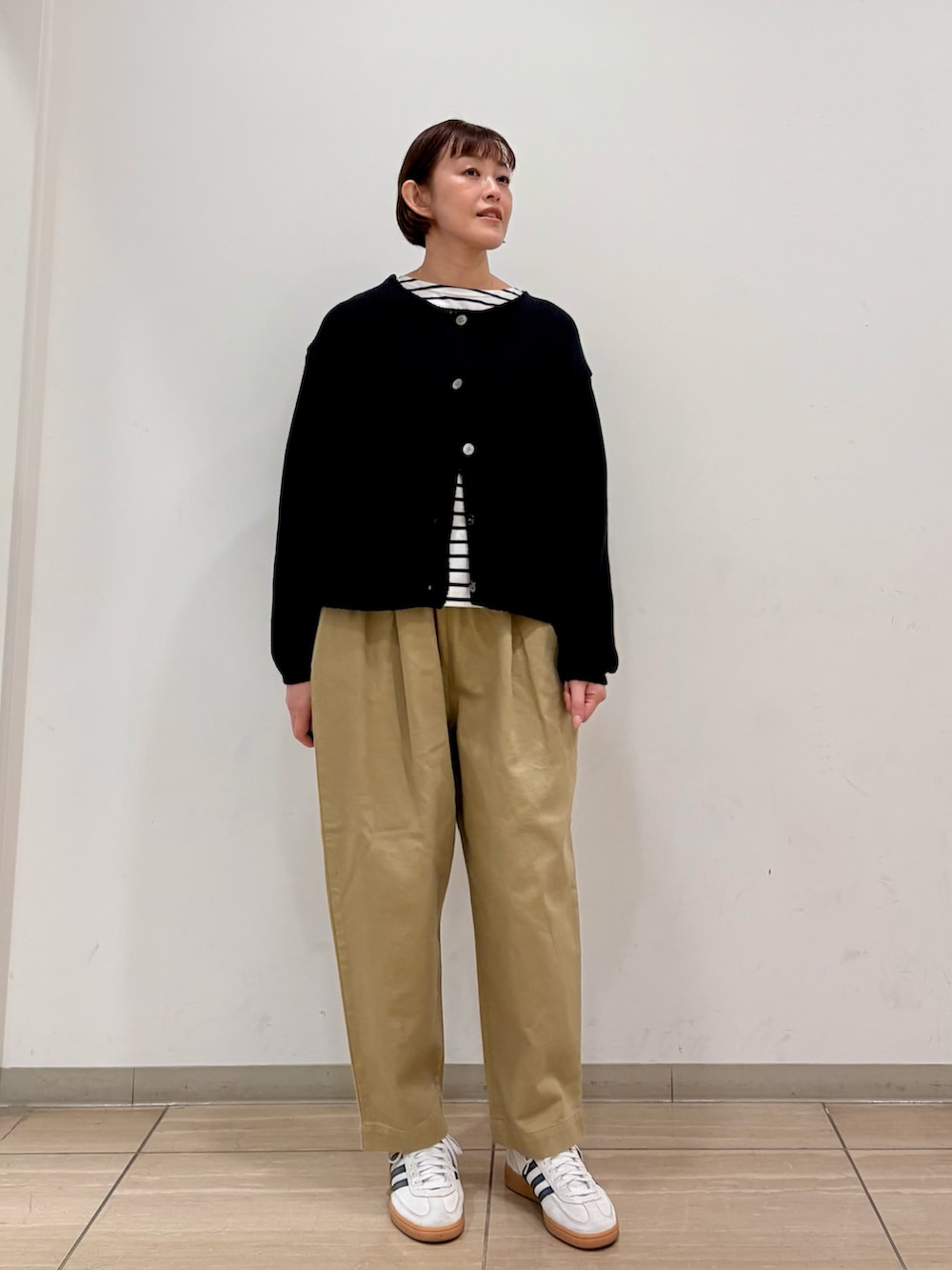 ブラック系のカーディガン/ボレロ、ブラック系のTシャツ/カットソー、ベージュ系のその他パンツを着用したレディースの冬コーディネートの4枚目の写真