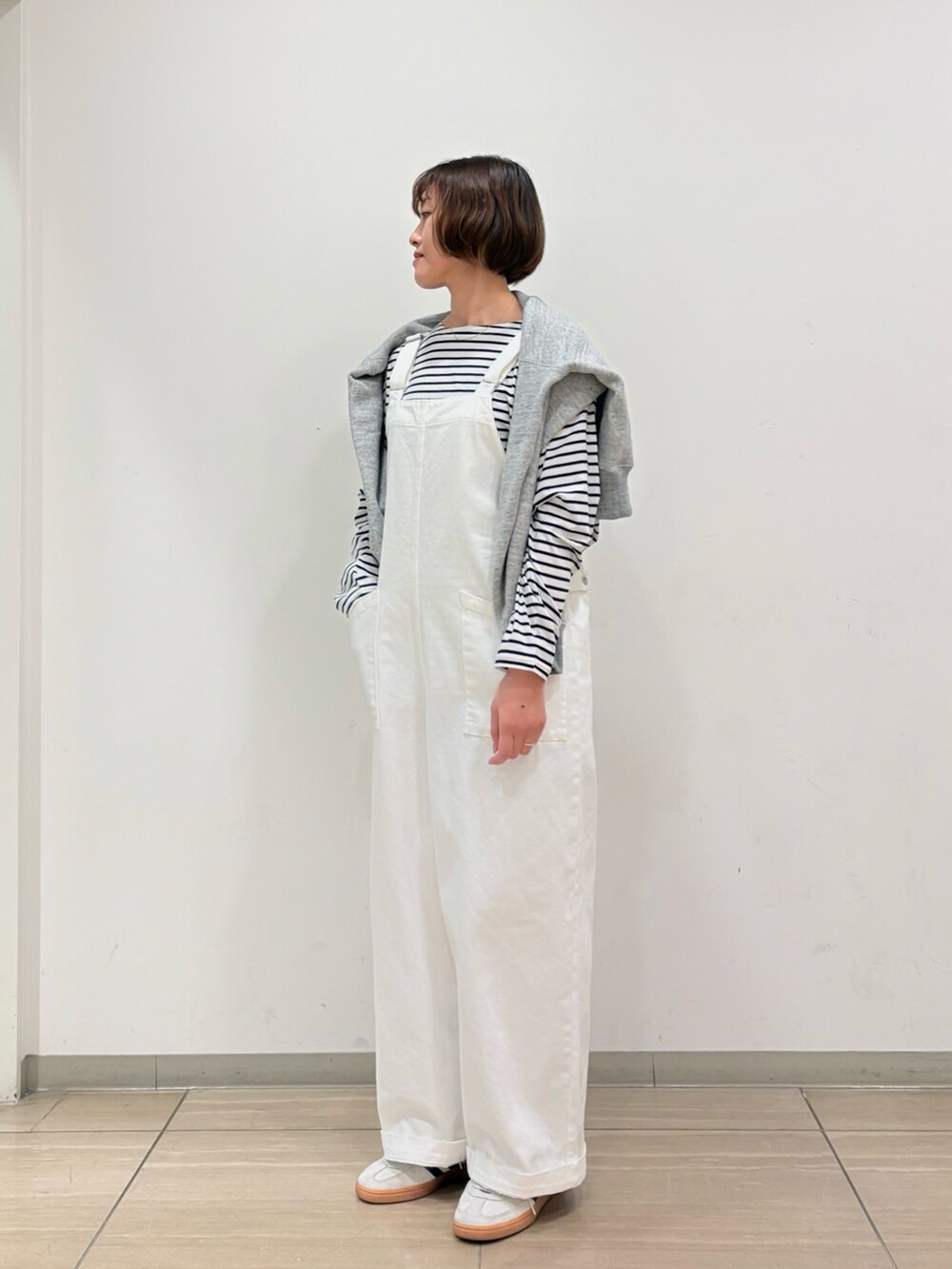 グレー系のスウェット、ホワイト系のサロペット/オーバーオール、ブラック系のTシャツ/カットソーを着用したレディースの冬コーディネートの3枚目の写真