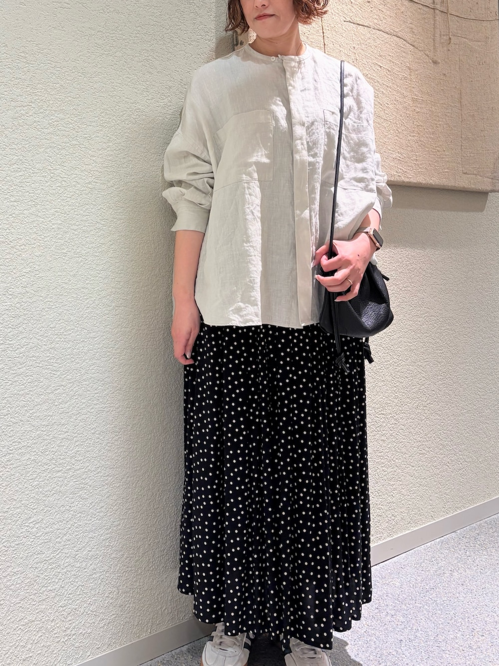 グレー系のシャツ/ブラウス、ブラック系のスカート、ブラック系のショルダーバッグを着用したレディースの春コーディネートの6枚目の写真