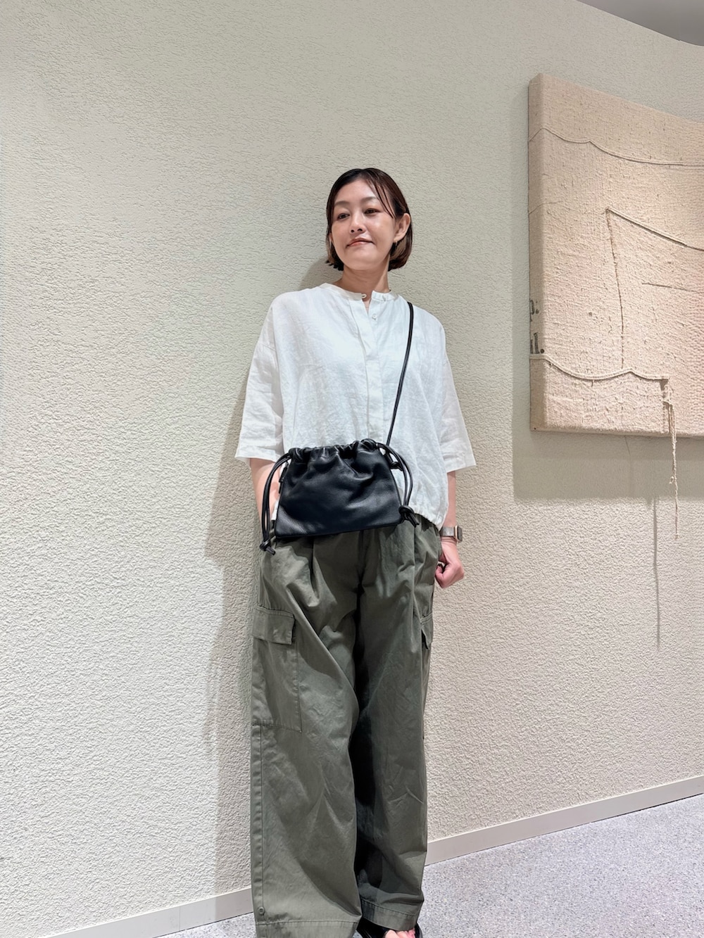 ホワイト系のシャツ/ブラウス、グリーン系のその他パンツ、ブラック系のショルダーバッグを着用したレディースの夏コーディネートの2枚目の写真