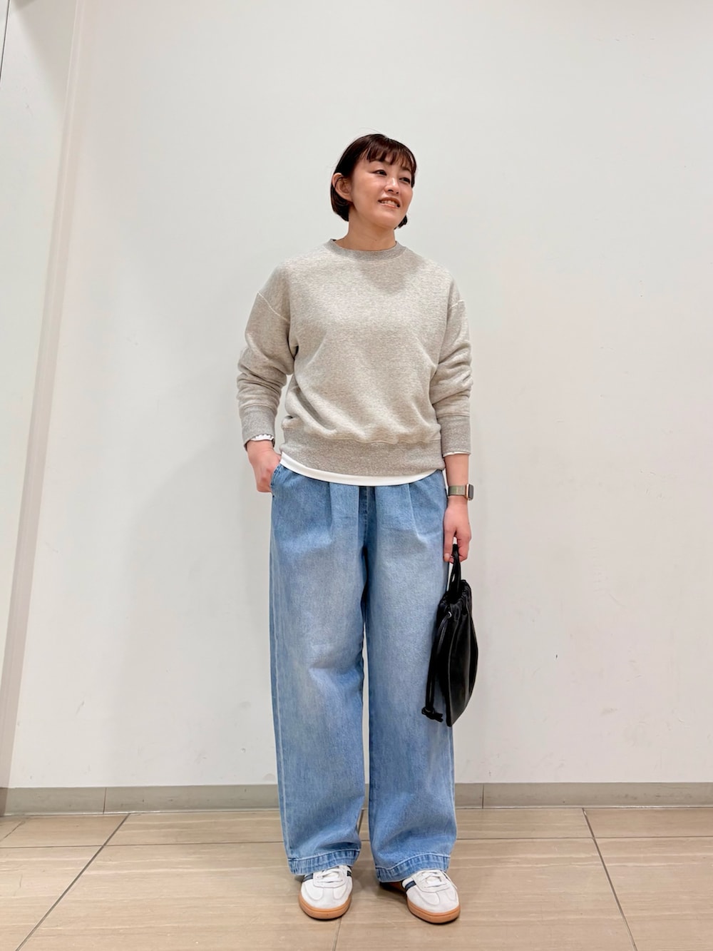 グレー系のスウェット、ブルー系のデニムパンツ、ブラック系のその他雑貨を着用したレディースの冬コーディネートの5枚目の写真