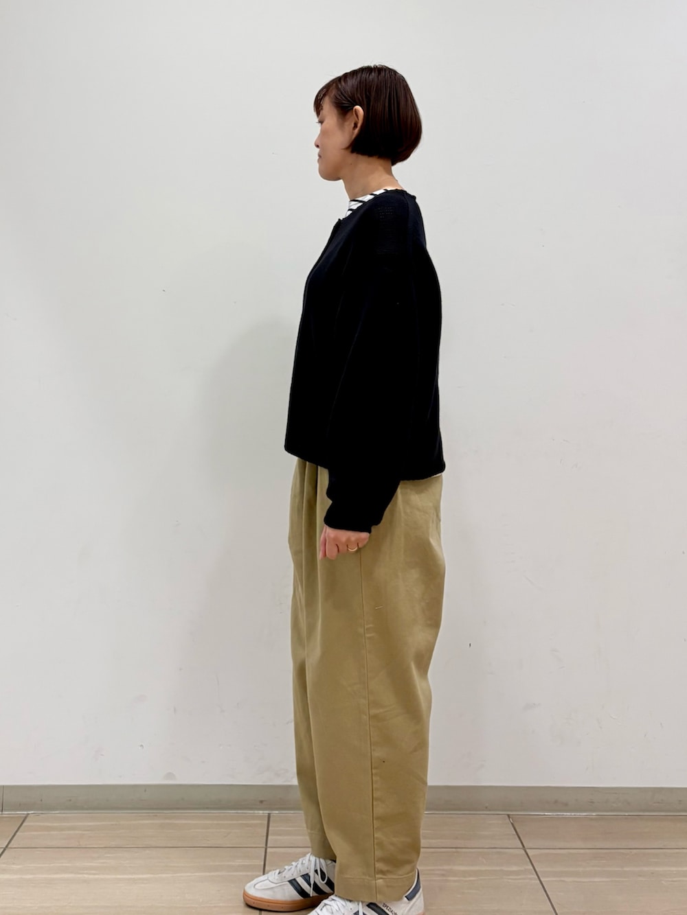 ブラック系のカーディガン/ボレロ、ブラック系のTシャツ/カットソー、ベージュ系のその他パンツを着用したレディースの冬コーディネートの5枚目の写真