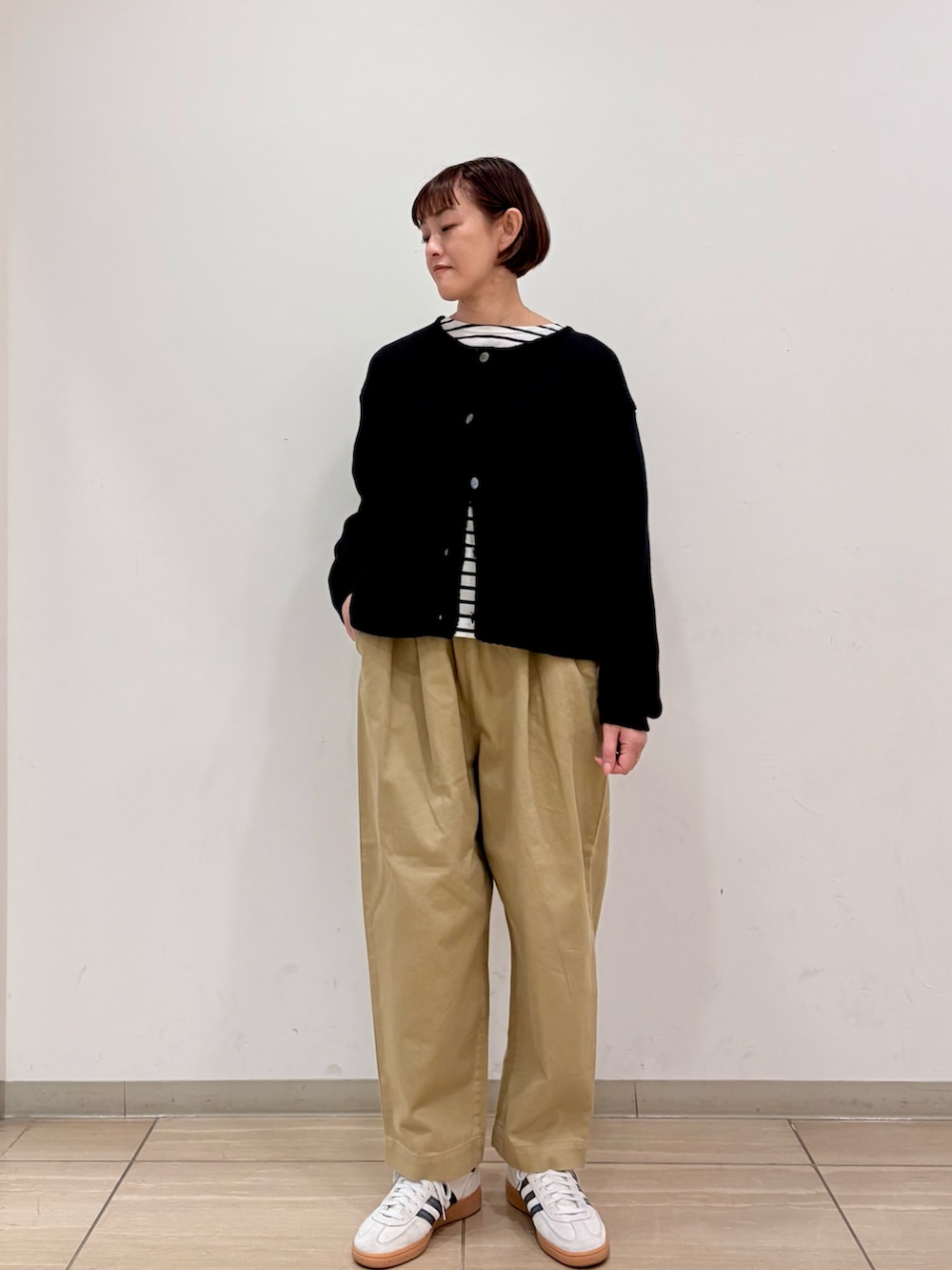 ブラック系のカーディガン/ボレロ、ブラック系のTシャツ/カットソー、ベージュ系のその他パンツを着用したレディースの冬コーディネートの2枚目の写真