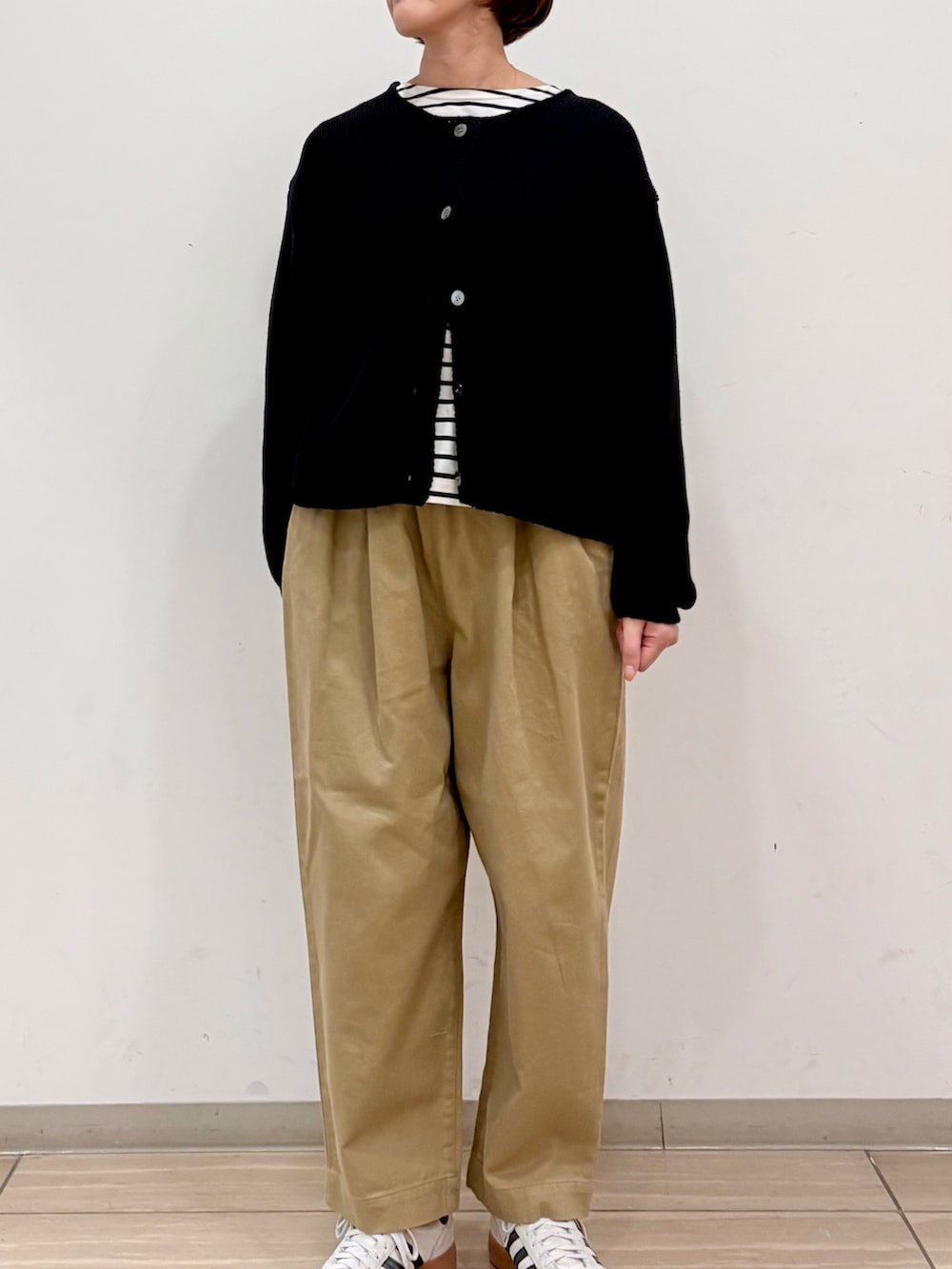 ブラック系のカーディガン/ボレロ、ブラック系のTシャツ/カットソー、ベージュ系のその他パンツを着用したレディースの冬コーディネートの6枚目の写真