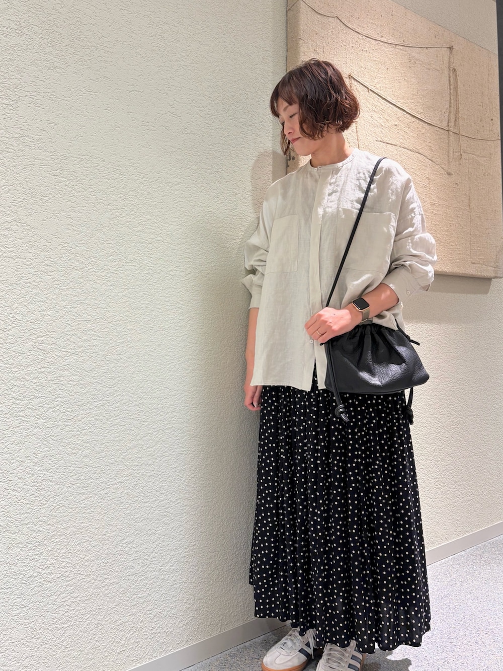 グレー系のシャツ/ブラウス、ブラック系のスカート、ブラック系のショルダーバッグを着用したレディースの春コーディネートの2枚目の写真
