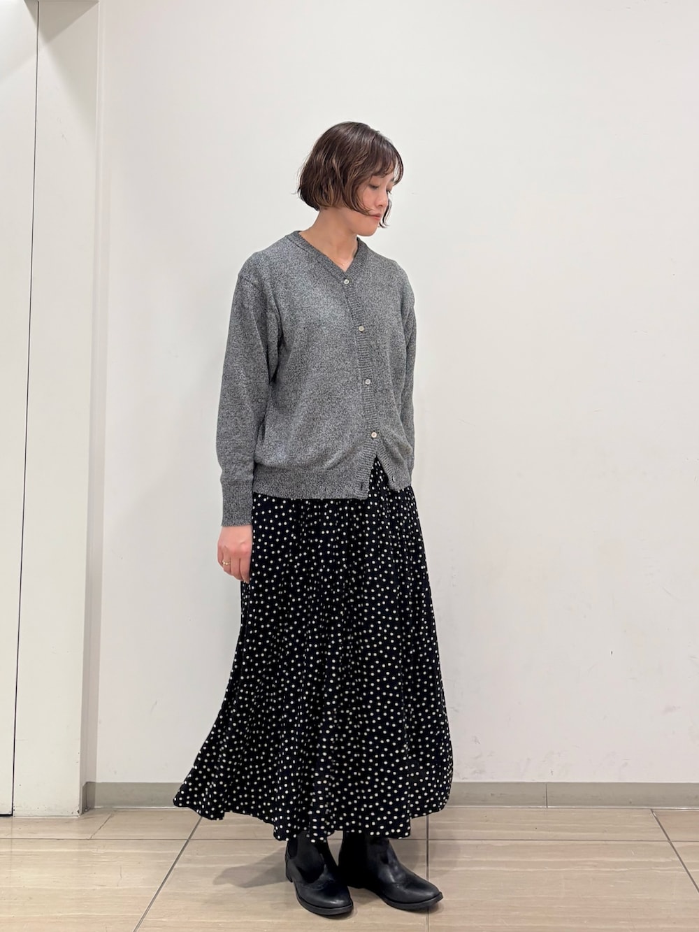 グレー系のニット/セーター、ブラック系のスカートを着用したレディースの冬コーディネートの3枚目の写真