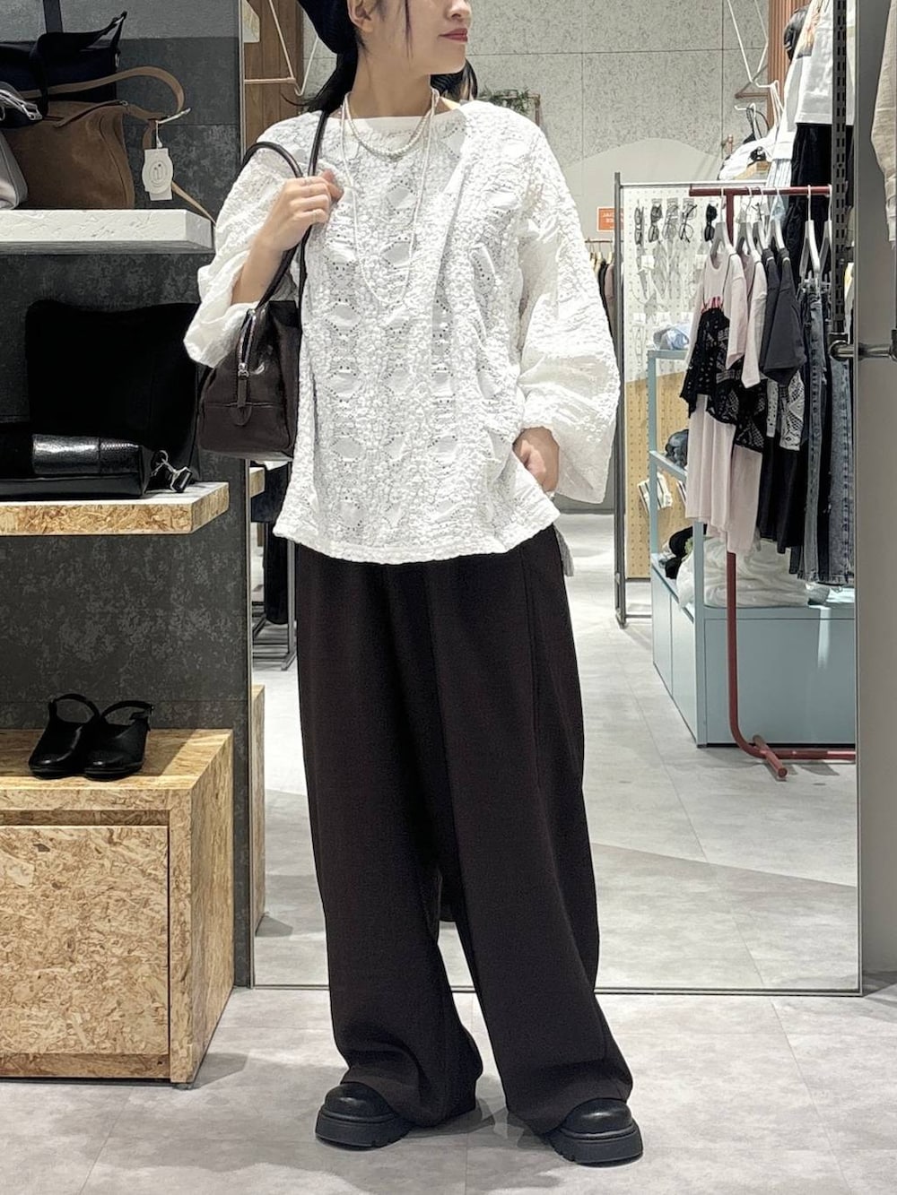 ブラック系のボストンバッグ、ブラック系のその他シューズ、ホワイト系のTシャツ/カットソーを着用したレディースの春コーディネートの2枚目の写真