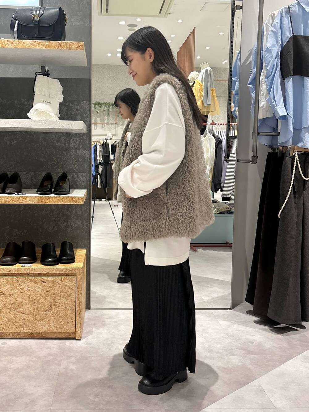 ブラック系のサンダル、ブラウン系のショルダーバッグ、ブラック系のスカートを着用したレディースの秋コーディネートの3枚目の写真