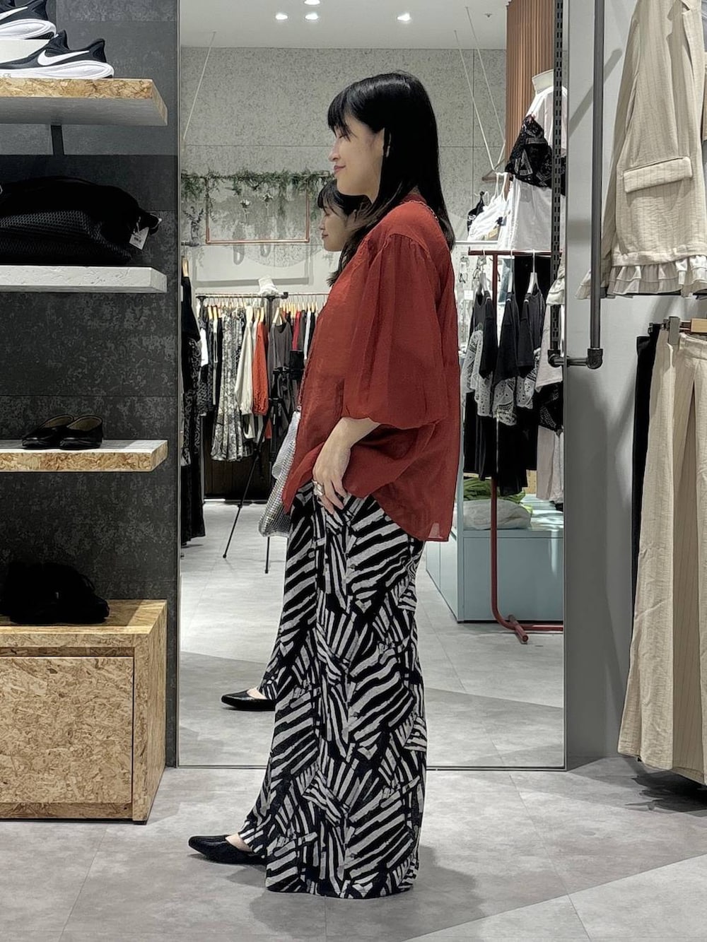 ブラック系のその他パンツ、レッド系のシャツ/ブラウス、シルバー系のショルダーバッグを着用したレディースの春コーディネートの3枚目の写真