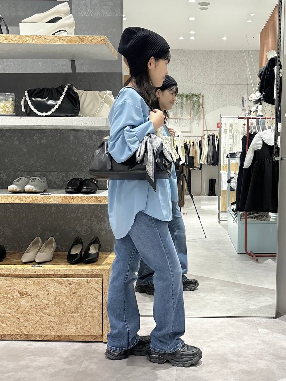 ブラック系のローファー、ブラック系のボストンバッグ、ブルー系のシャツ/ブラウスを着用したレディースの冬コーディネートの5枚目の写真